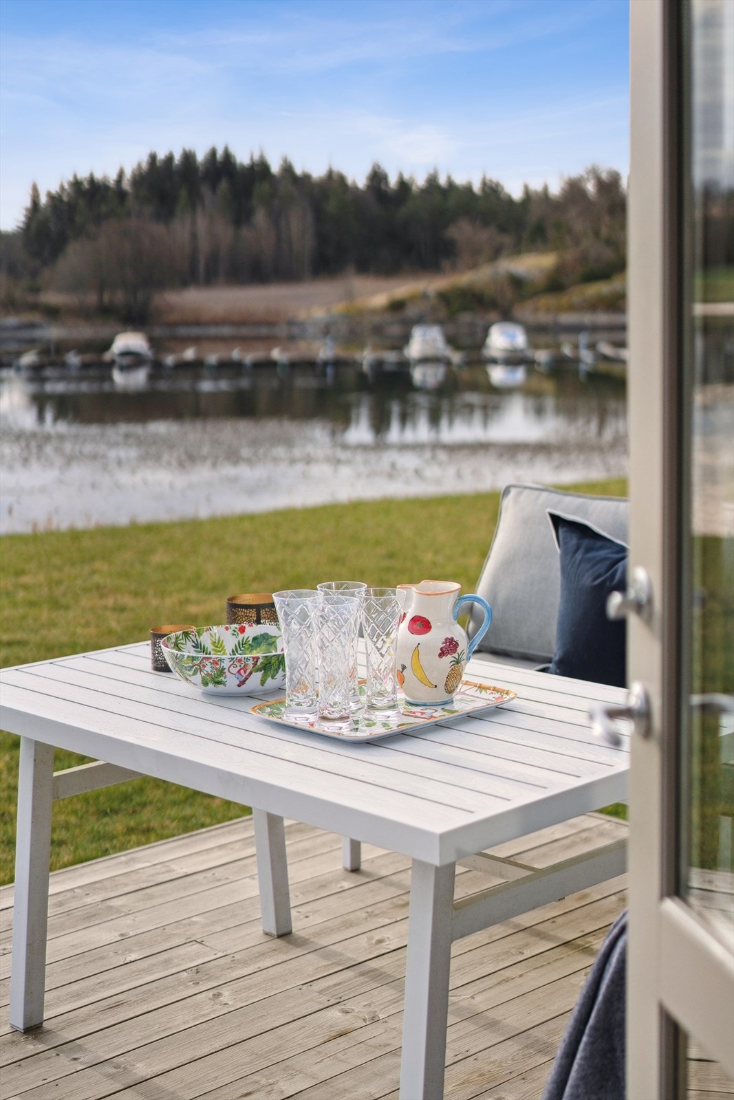 Det er fine solforhold med nydelig morgensol og sol utover store deler av dagen på den sjøvendte terrassen - plenen er sameiets fellesareal men blir i praksis benyttet av hyttene i første rekke Galleribilde