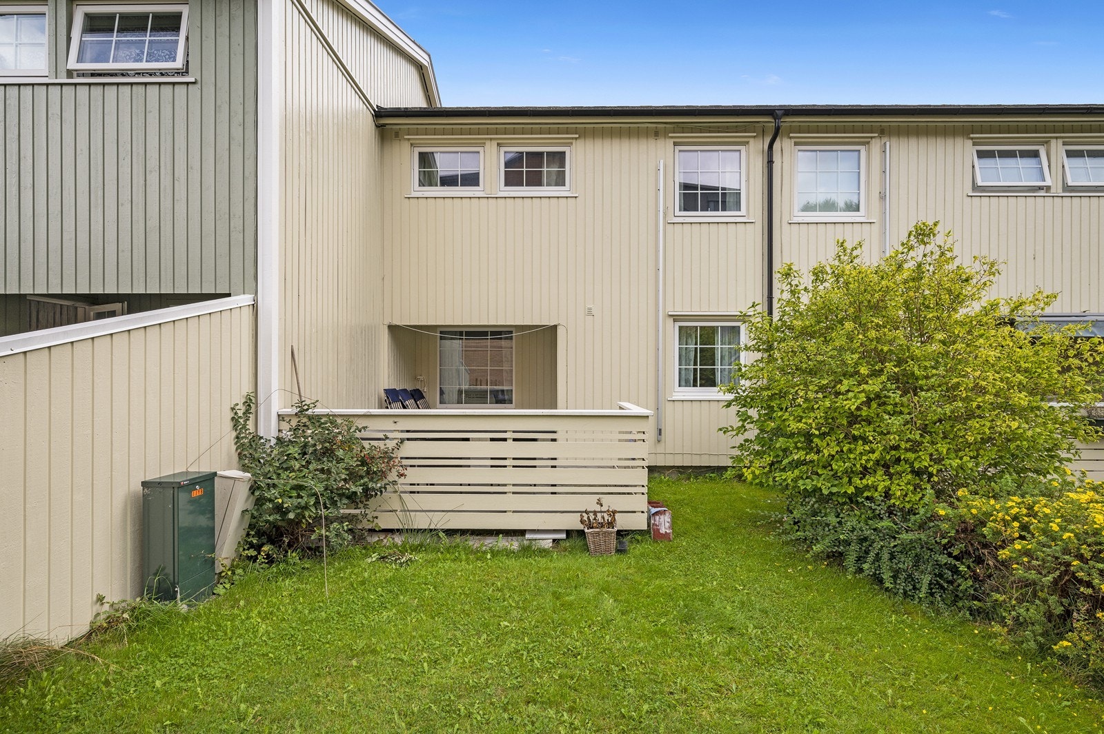 Rekkehuset har en klassisk utforming og er en del av et etablert og rolig boligområde. Rekkehuset fra 1985 har en fasade med stående bordkledning og PVC-vinduer installert i 2019. Galleribilde