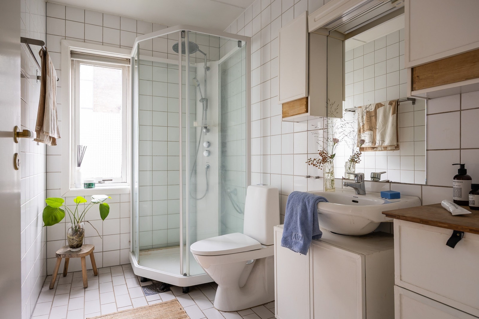 Badet er fra byggeår og er innredet med dusjkabinett, skap med overliggende servant, speil med belysning og toalett. Galleribilde