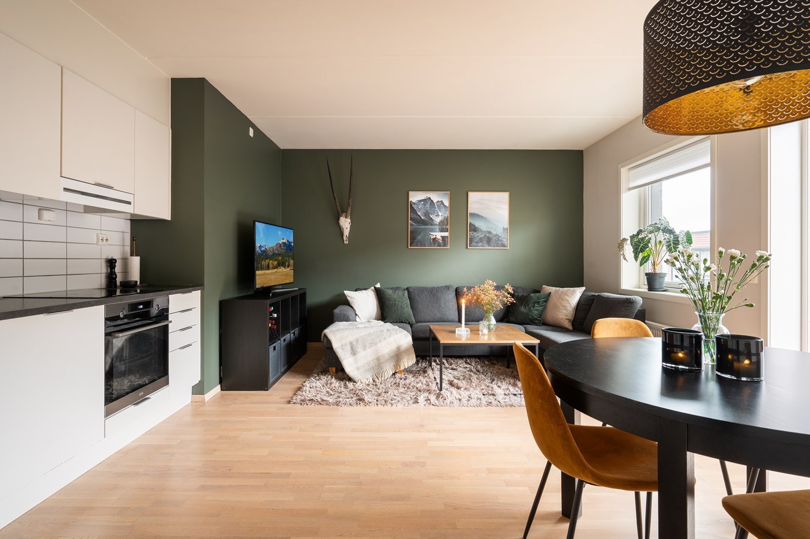 Leiligheten har en romslig og åpen stue-/kjøkkenløsning som skaper en sosial atmosfære, med god plass til sofagruppe Galleribilde