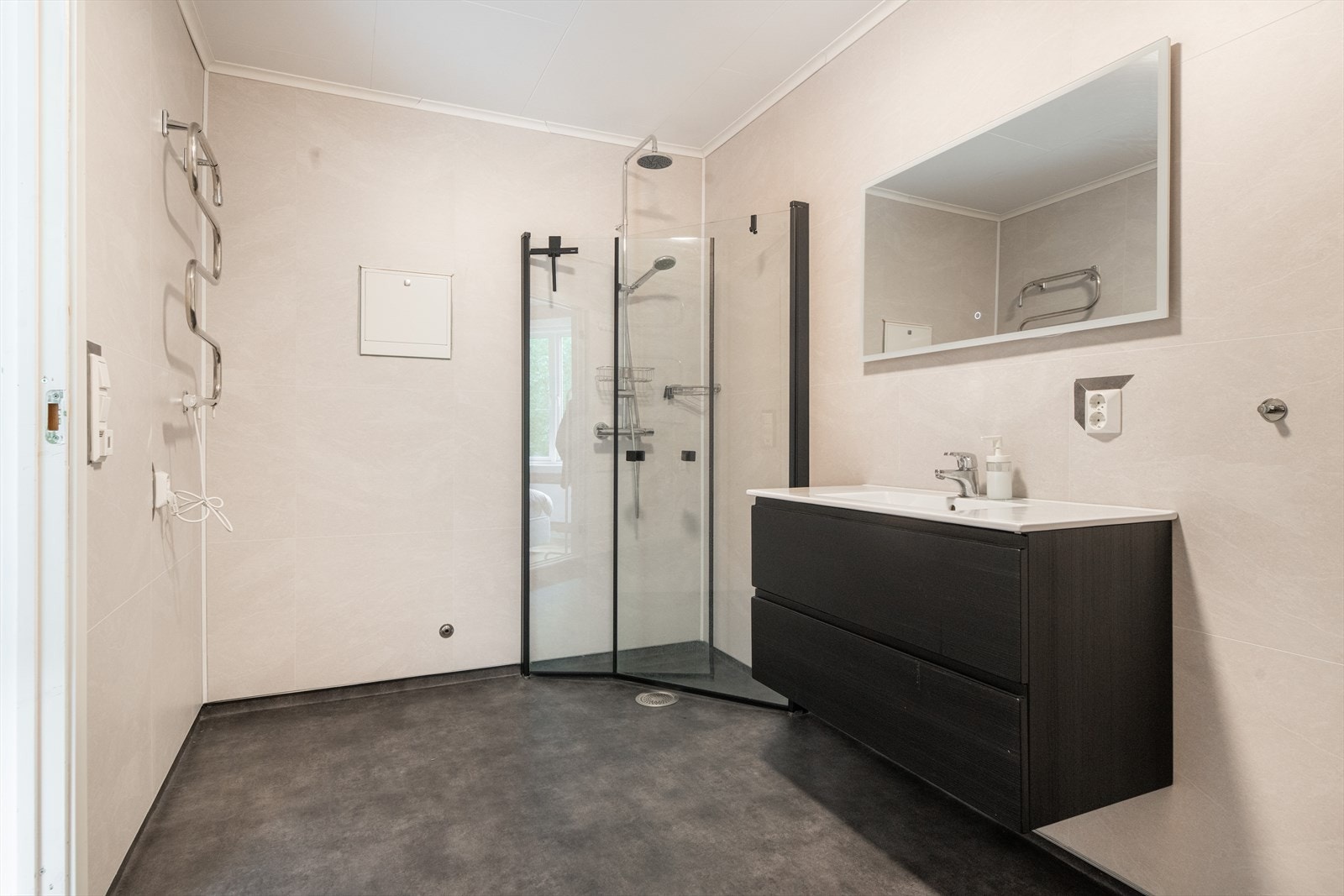 Innredning i mørk utførelse med dype skuffer og heldekkende servant. Speilet har integrert belysning som gir et varmt og behagelig lys. Galleribilde