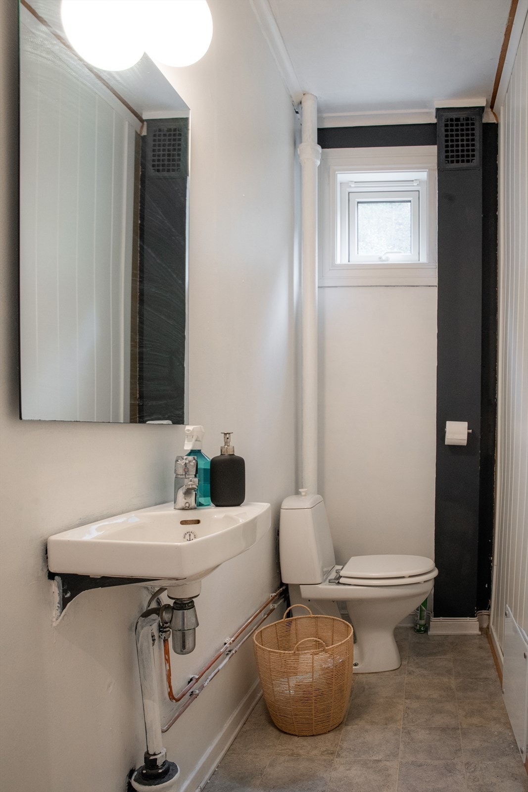 Leiligheten har separat toalettrom med enkel servant og speil med overlys. Overflater er belegg på gulv og malte plater på veggene. Veggmontert panelovn som varmekilde. Galleribilde