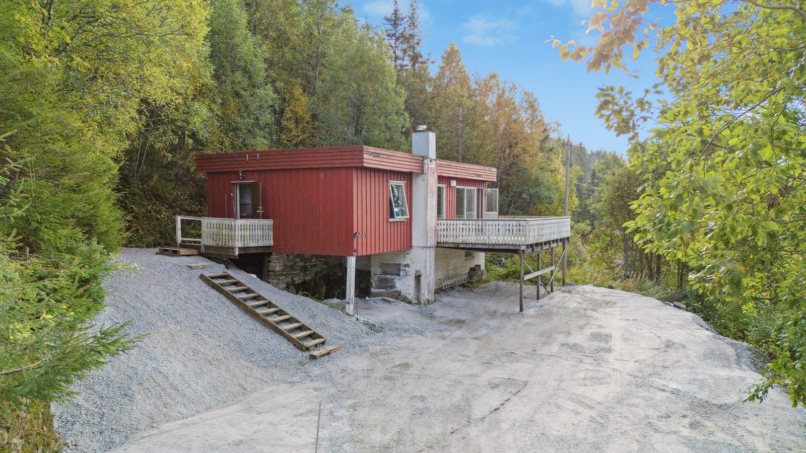 Tomten er skrående og terrassert med gruslagt innkjørsel. Galleribilde