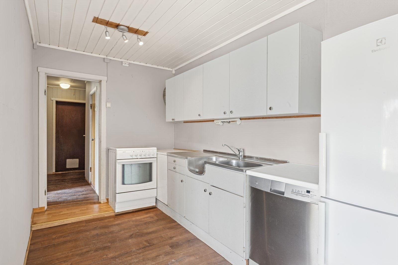 Kjøkkeninnredning av laminerte skrog med laminerte slette fronter, laminert benkeplate og benkebeslag i rustfritt stål med oppvaskkum og ett-greps blandebatteri. Galleribilde