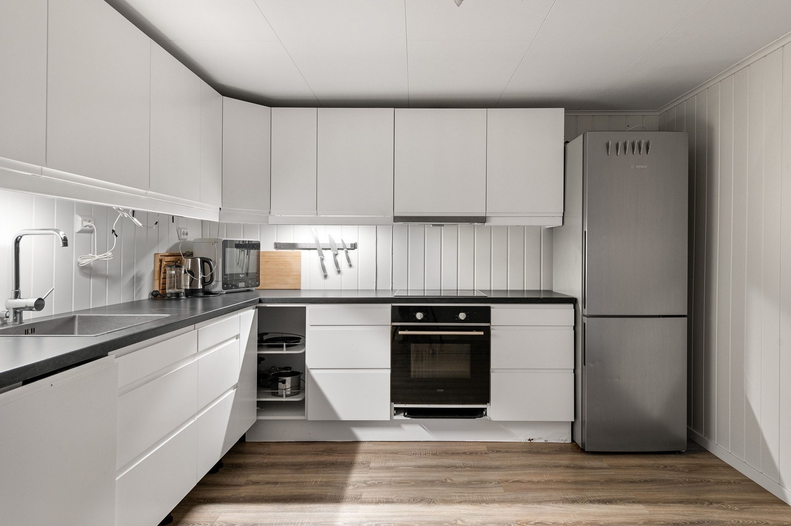 Lyst og funksjonelt kjøkken i kjelleren, innredet i 2018 med integrerte hvitevarer. Galleribilde