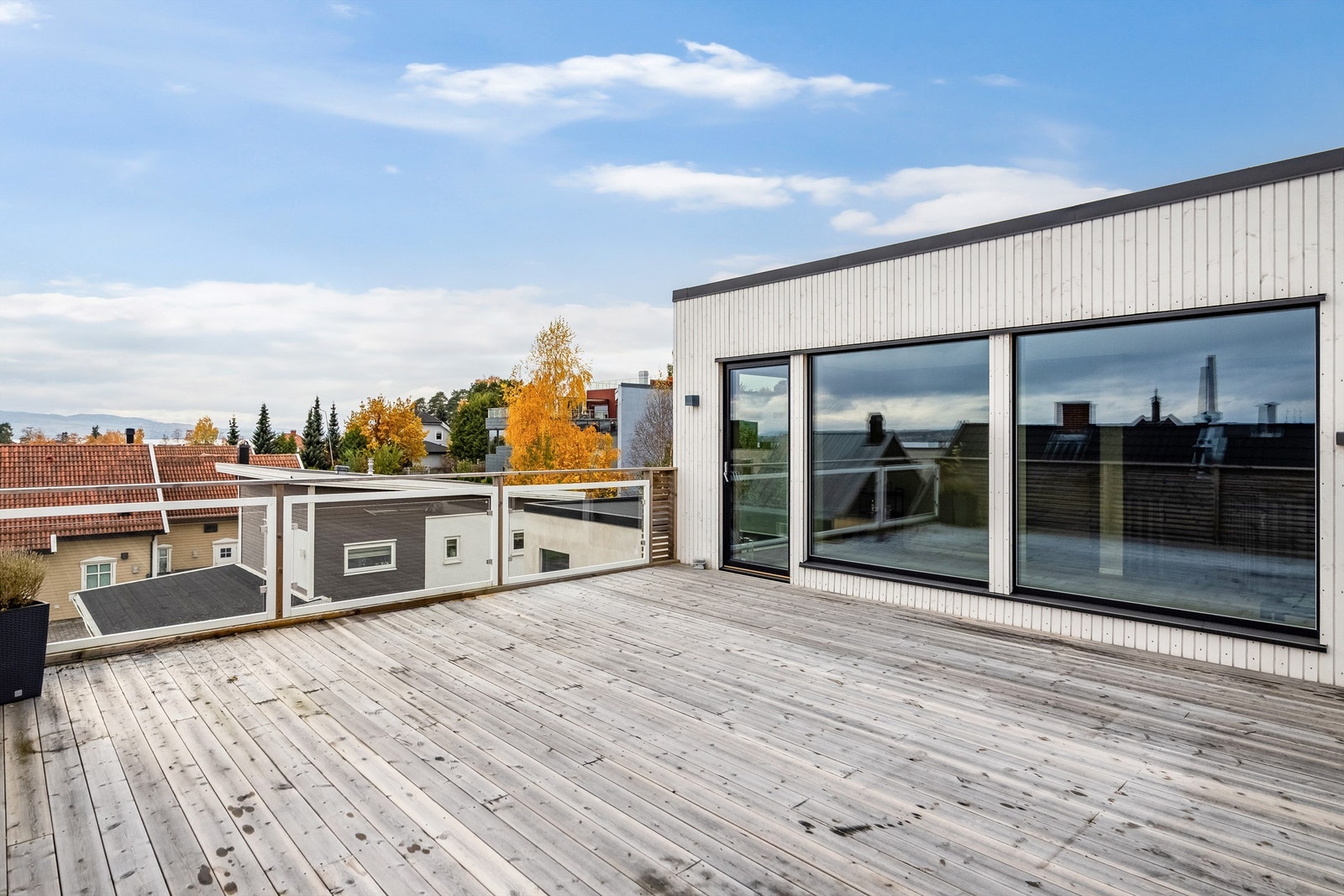 Romslig terrasse på 35m² med glassrekkverk og flott utsikt mot Mjøsa i 2. etasje av boligen. Galleribilde