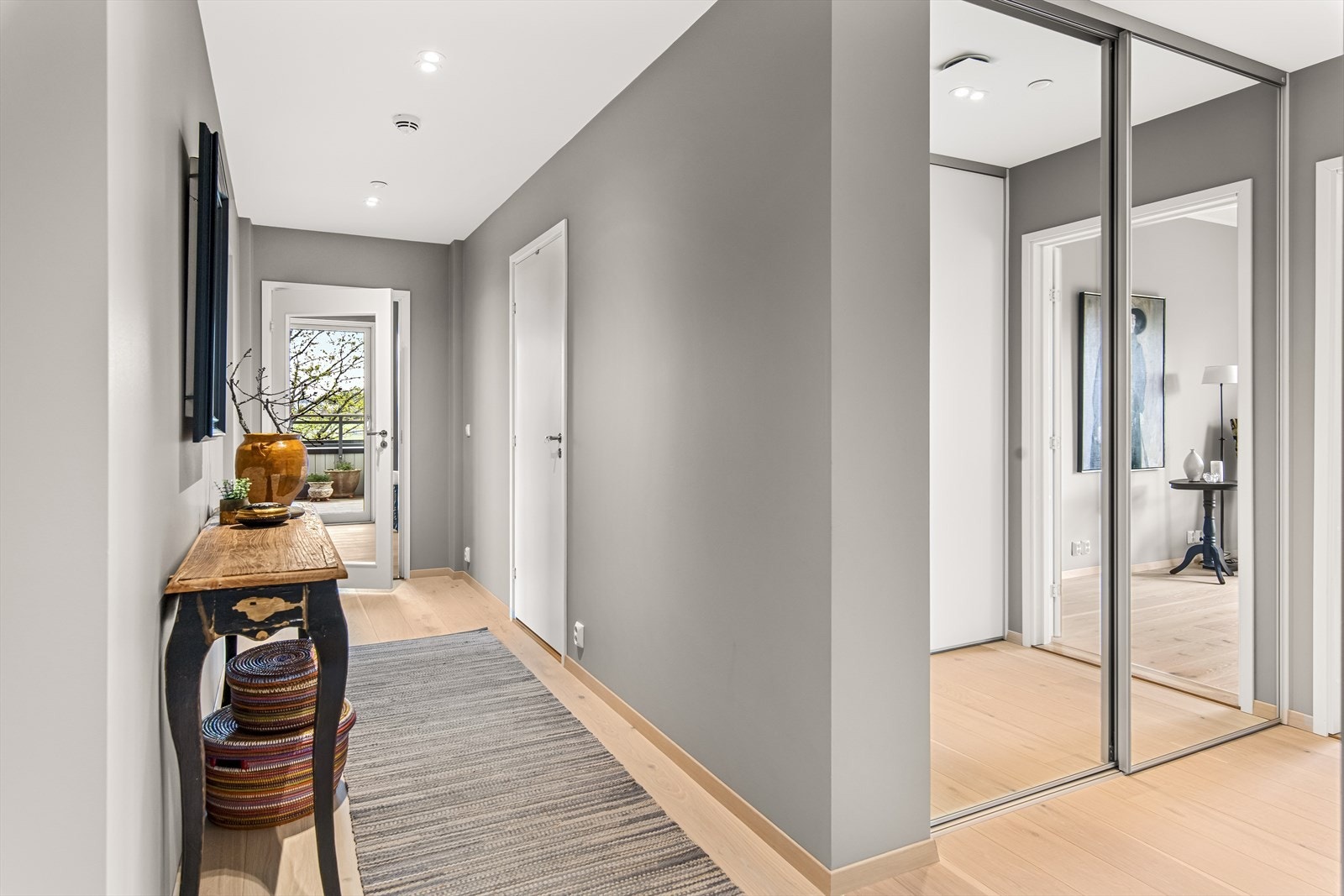 Entreen er langstrakt med downlights i himling og utsyn til terrassen på motsatt side, via glassdør i tv-stuen. Galleribilde