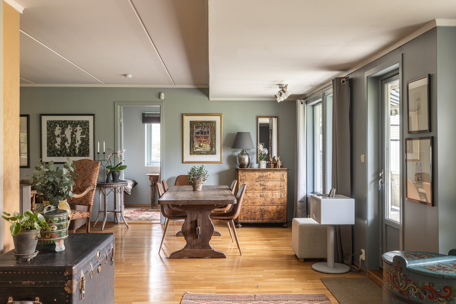 Rommet har parkettgulv, glatte, malte veggflater, hvitmalt himling, og dører med sprosseglass både mot soverommet og entreen. Galleribilde