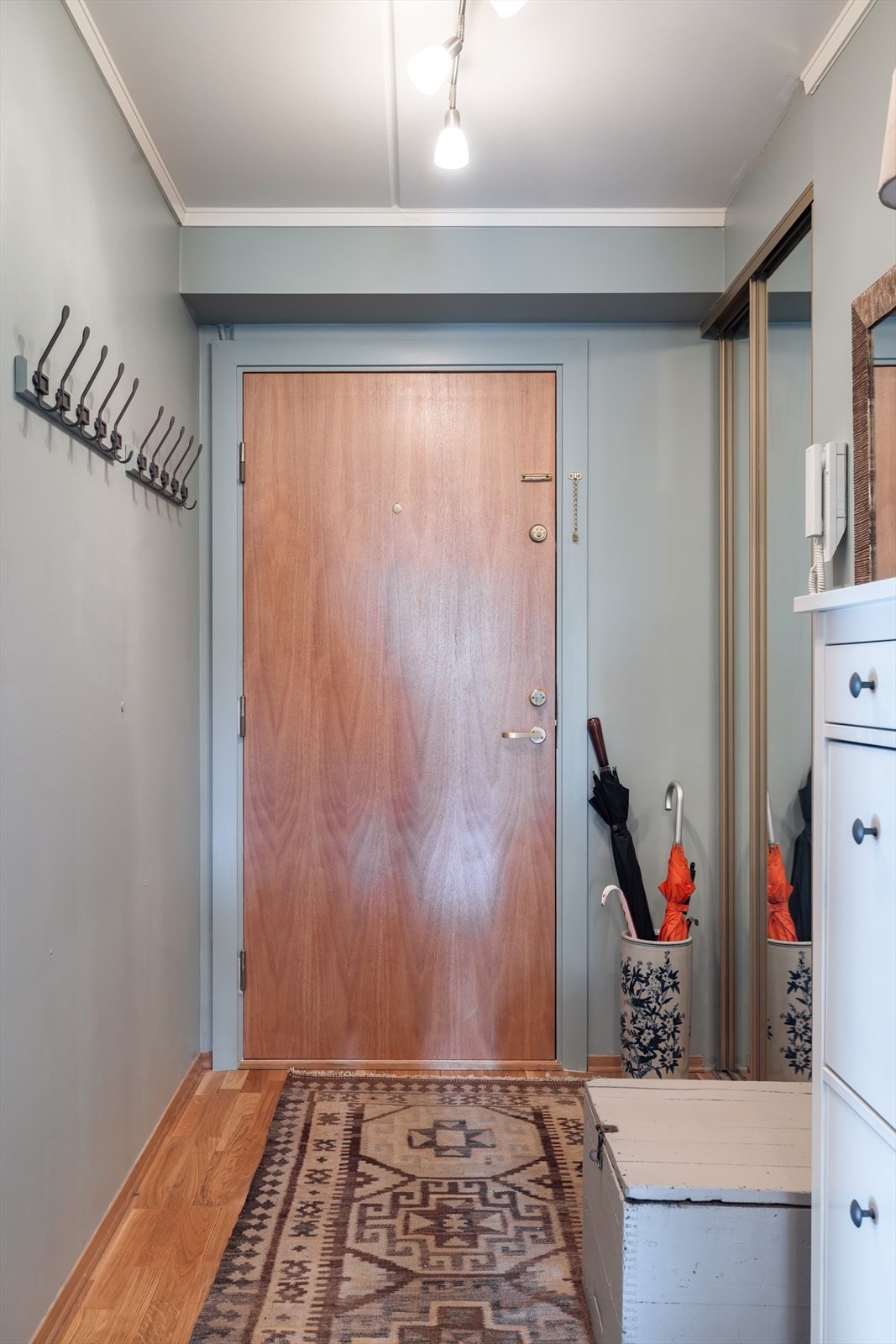 Ved inngangspartiet er det integrert en praktisk skyvedørsgarderobe med speilfronter, mens motsatt vegg har en montert knaggrekke for enkel hverdagsbruk. Galleribilde