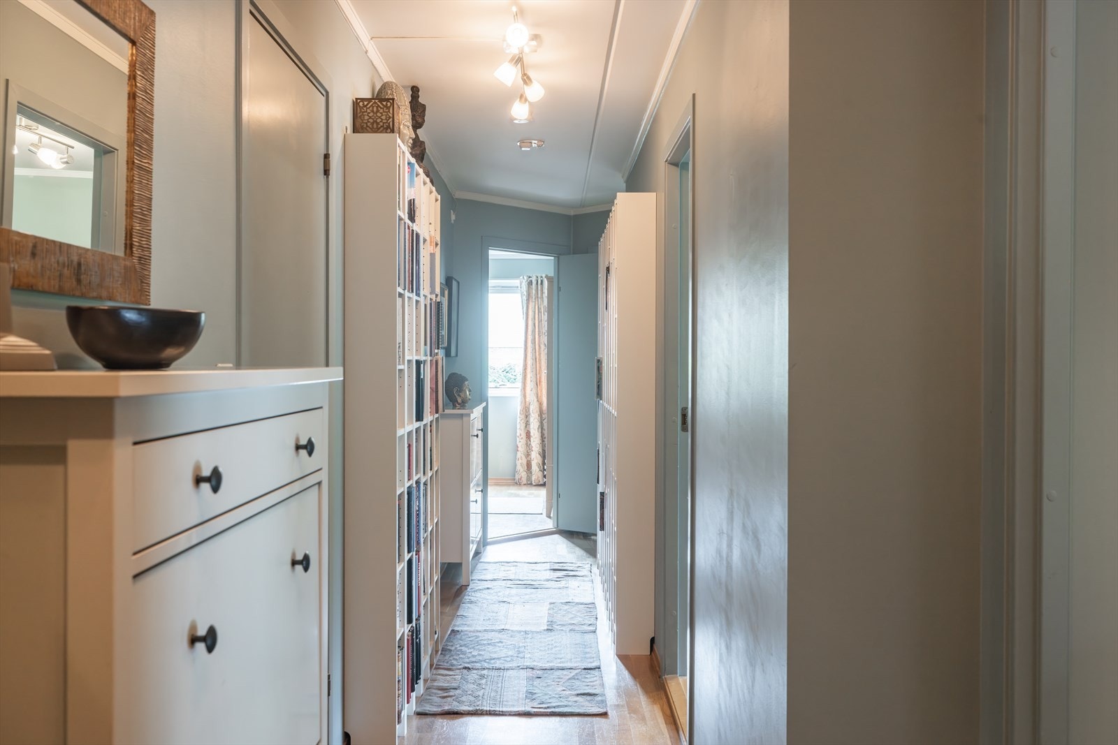 Avlang entré som strekker seg innover i leiligheten, med plass til bokhyller eller annen oppbevaring. Galleribilde