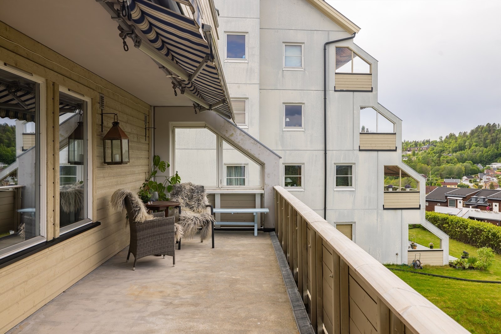 Plasseringen er usjenert, uten bygg i front og helt uten innsyn. Terrassen har rekkverk i tre, dekke av lettstelt betong, utebelysning og stikk, samt noe overbygg innerst og to markiser i overbygget. Galleribilde