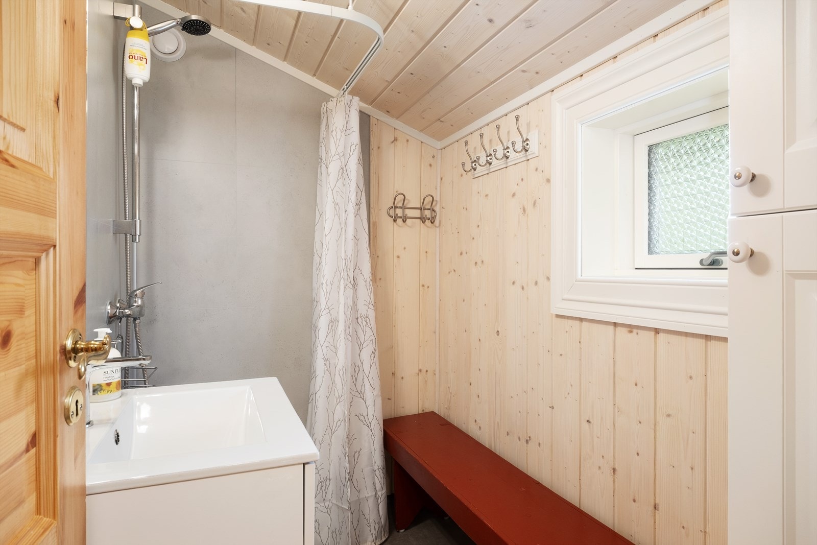 Baderom med vinylbelegg på golv med oppbrett, panel på veggar og i himling. Det er ikkje innlagt toalettløysing, toalett er plassert i utebod. Galleribilde