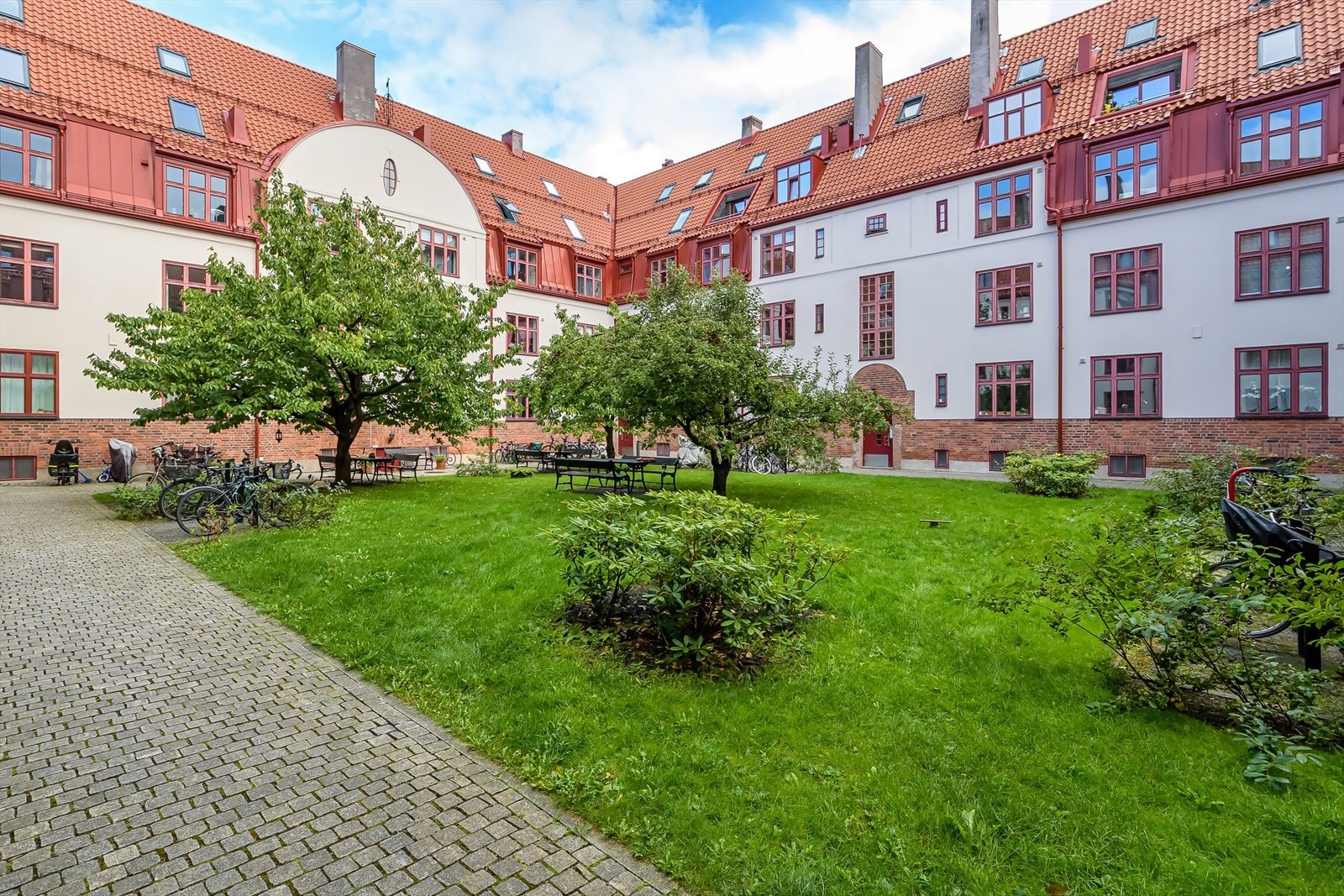 Sameiet har et nydelig gårdsrom med flere sitteplasser, beplantning og sykkelparkering Galleribilde