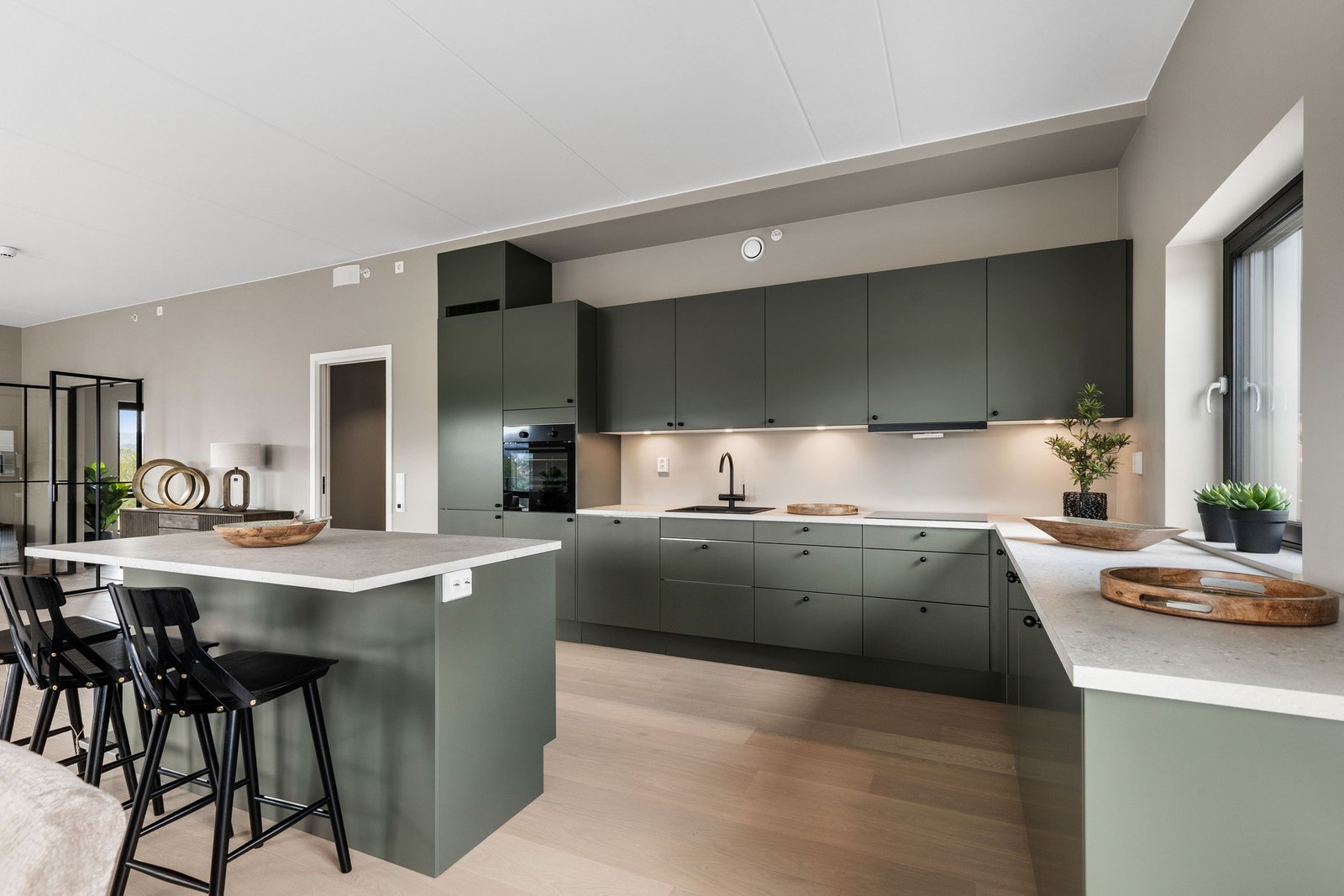 Kjøkkenet er levert av Sigdal og har glatte, grønne fronter, sort benkeplate med nedfelt vask og rikelig med skap- og benkplass. Galleribilde