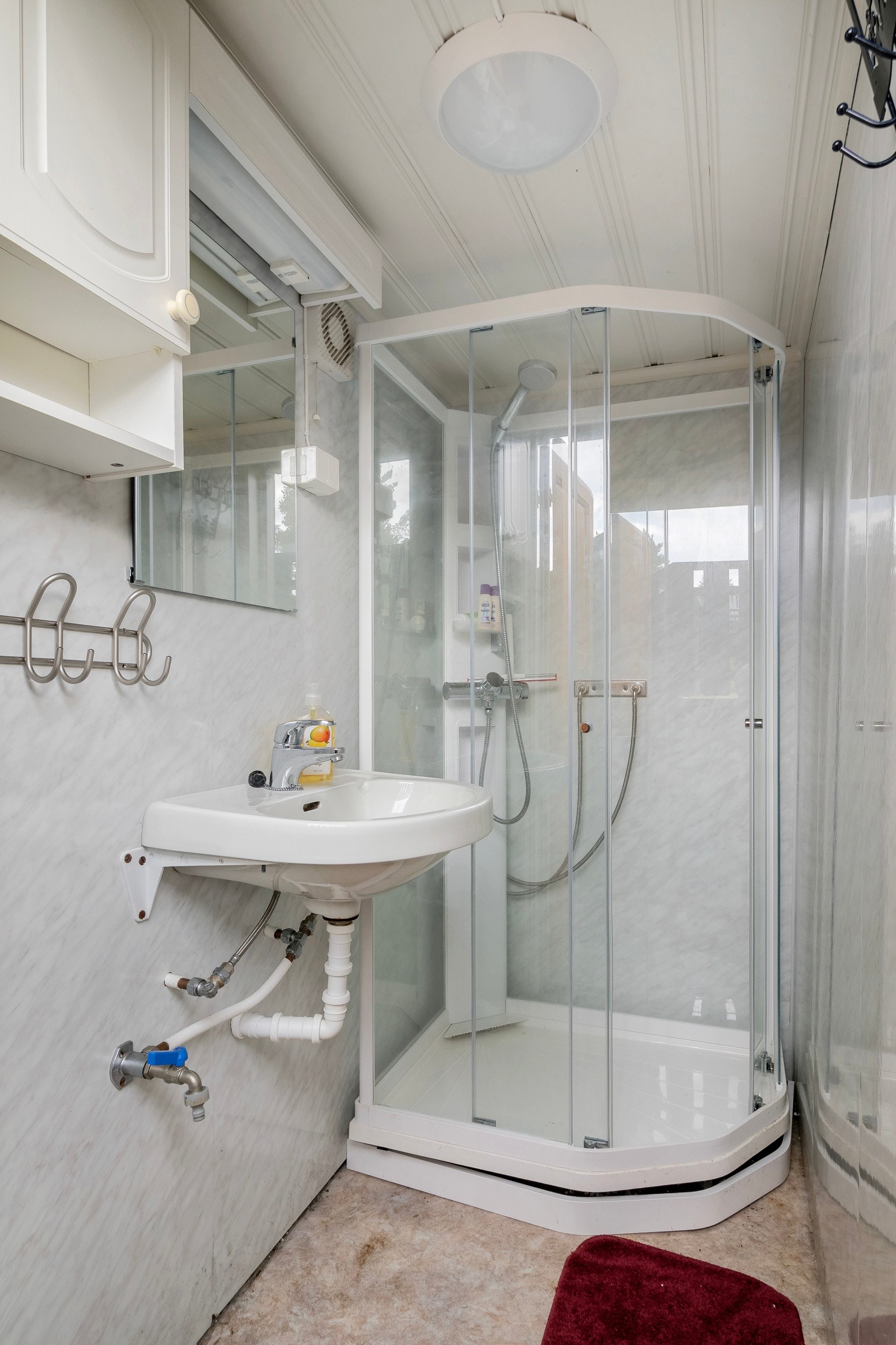 Enkelt bad med dusjkabinett og servant. Galleribilde