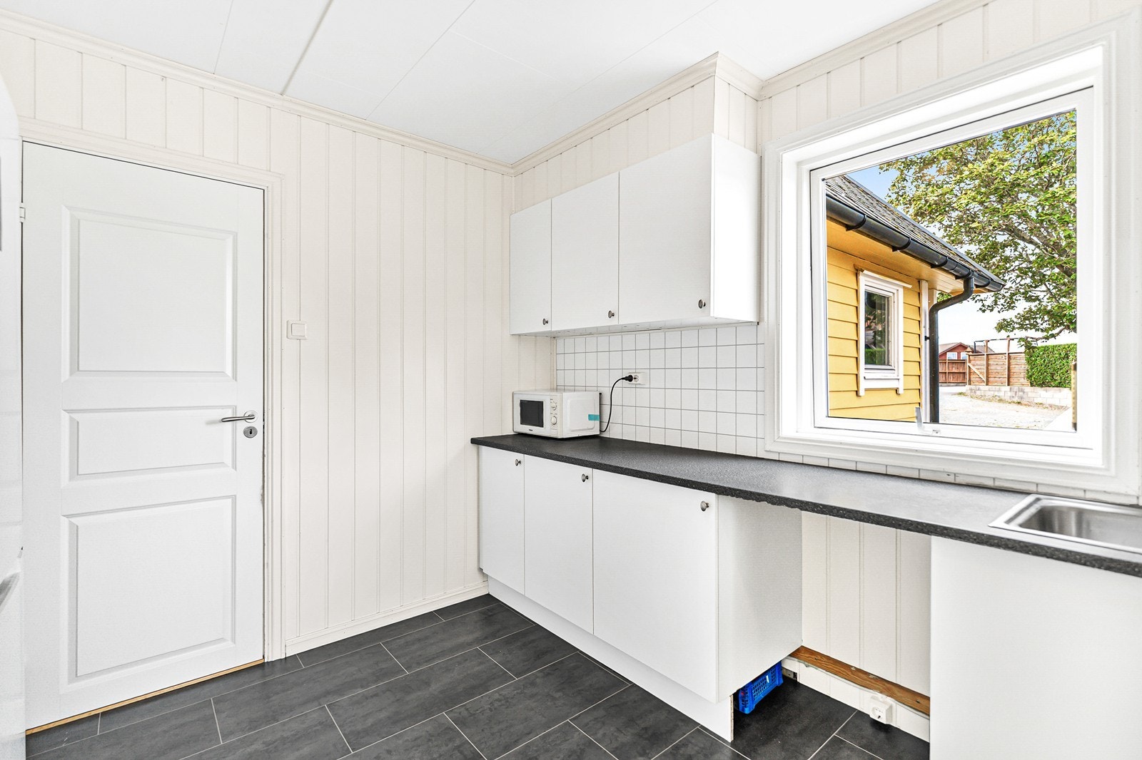 Kjøkkenet er innredet med slette fronter og laminat benkeplate. Galleribilde