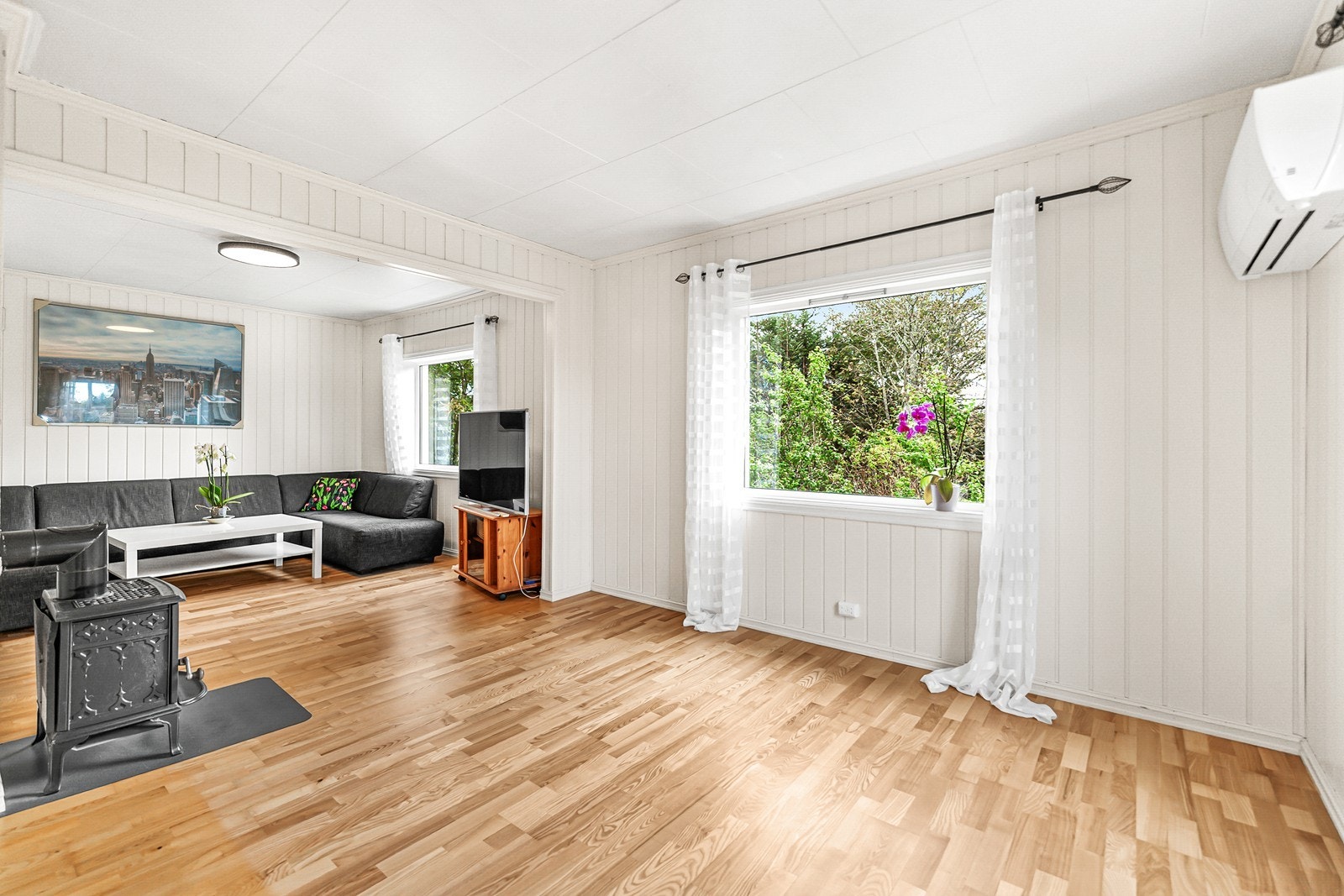 Det er både vedovn og varmepumpe i stuen. Varmepumpen er fra 2018. Galleribilde