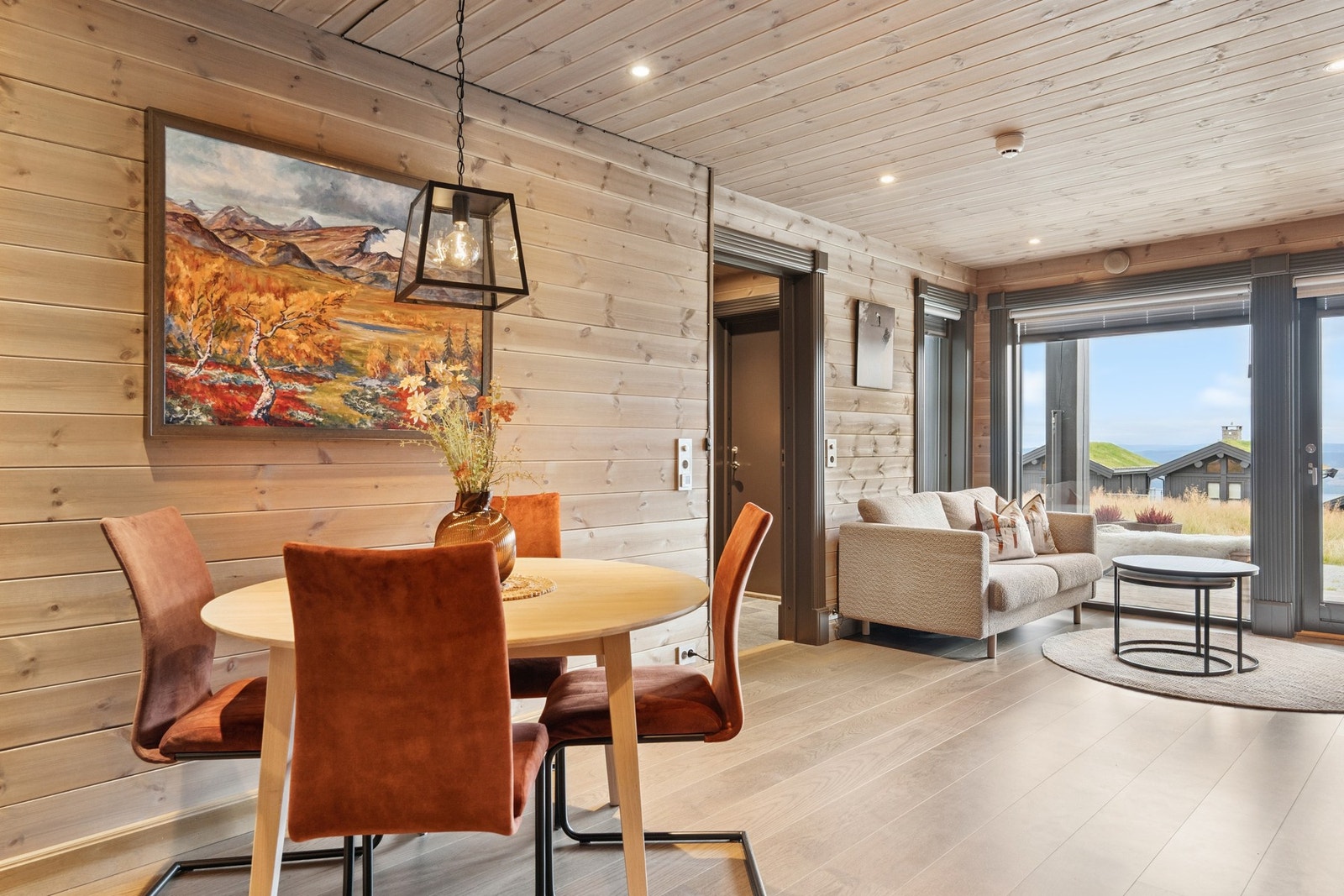 Leiligheten har en åpen og innbydende stue- og kjøkkenløsning med plass til sofagruppe og spisebord Galleribilde