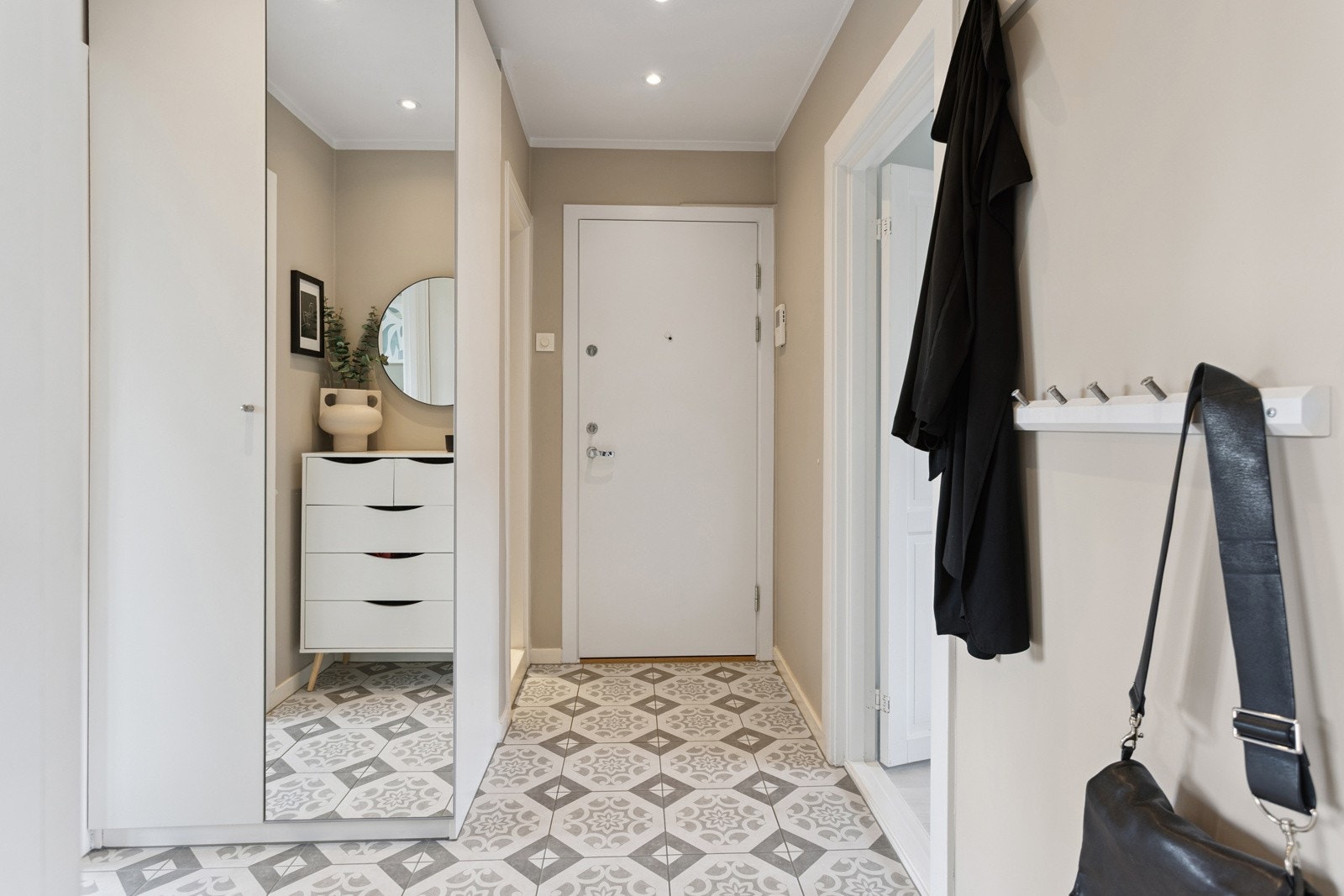 Innbydende entré med god plass til yttertøy i skyvedørsgarderobe. Galleribilde