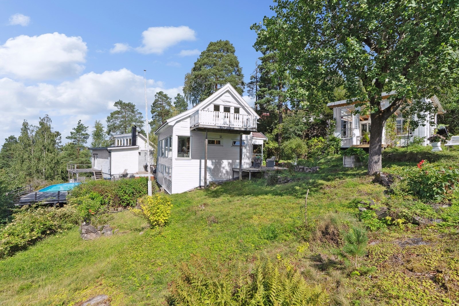 Tomten er meget stor, åpen og lys. Skrånende, fjelltomt/naturtomt, noe opparbeidet med plen og beplantninger. Galleribilde