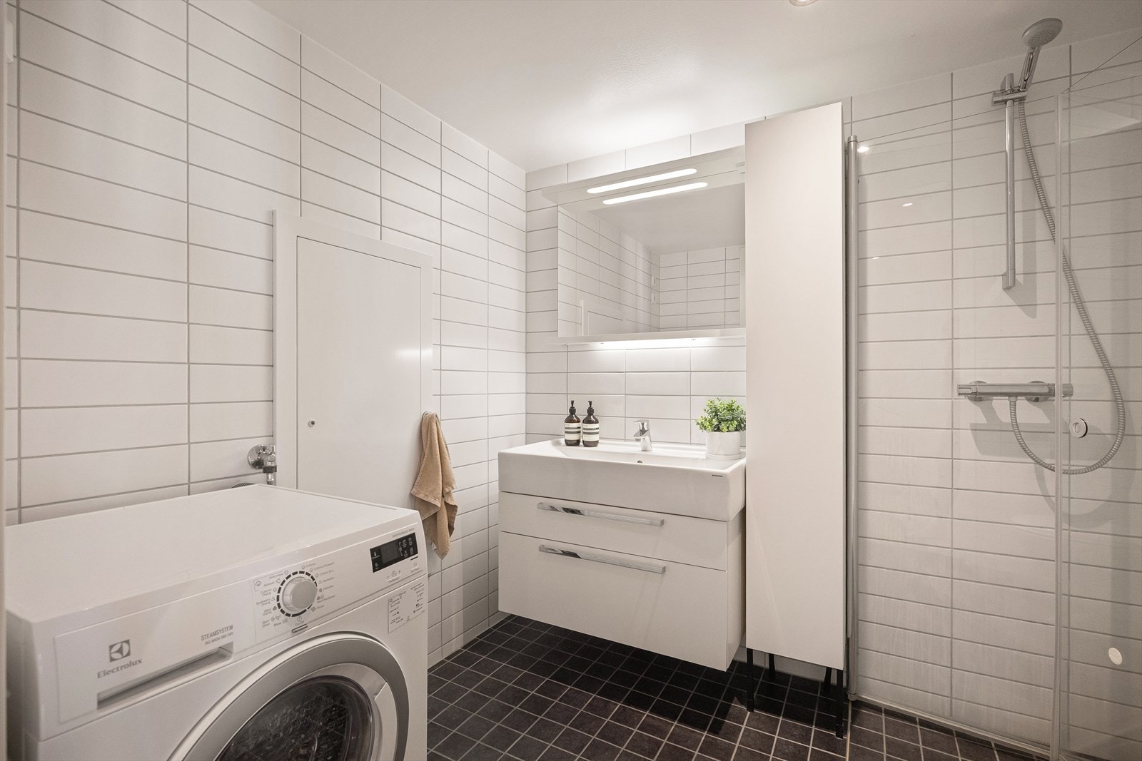 Delikat og praktisk bad fra 2014 med flislagte overflater, behagelig gulvvarme og downlights i himling. Galleribilde