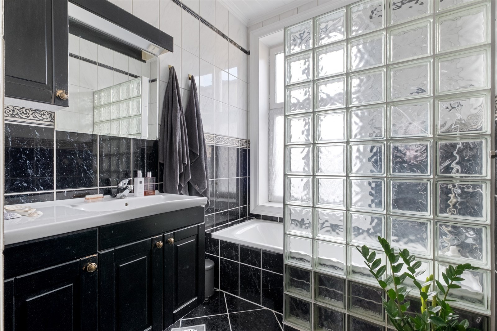 - Flislagt baderom. Baderommet er innredet med servant med innredning og badekar med dusj. Opplegg for dusjkabinett - Galleribilde