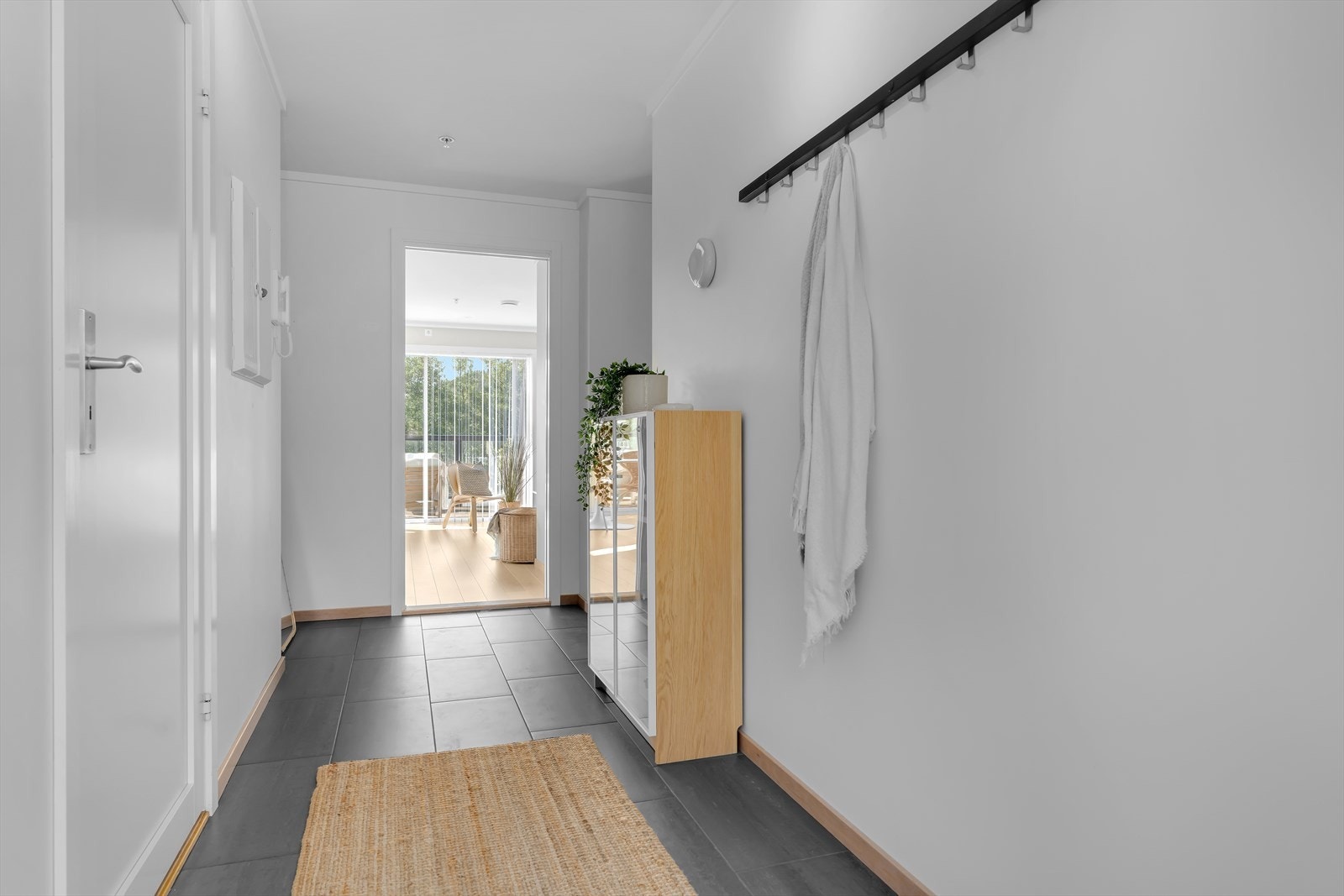 Innbydende entre med flis på gulv og lysmalte gipsvegger - callinganlegg på vegg Galleribilde