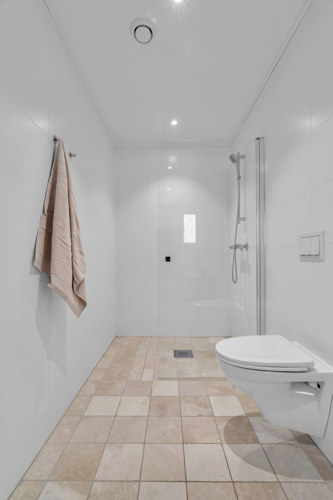 Her er det dusjnisje, veggmontert toalett og heldekkende servant i baderomsinnredning. Her er det også opplegg til vaskemaskin Galleribilde