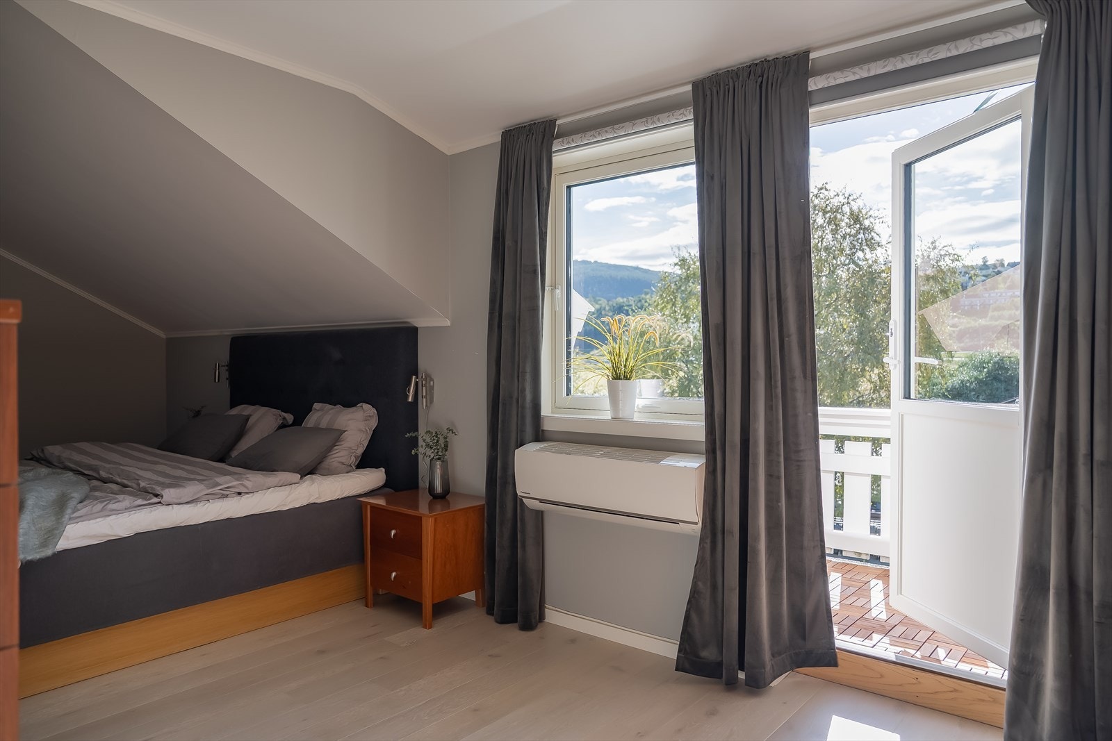 Stort hovedsoverom på 19,8 m² med egen balkong, varmepumpe/aircondition og stor garderobeløsning. Her er det byttet vindu og verandadør i 2024. Galleribilde