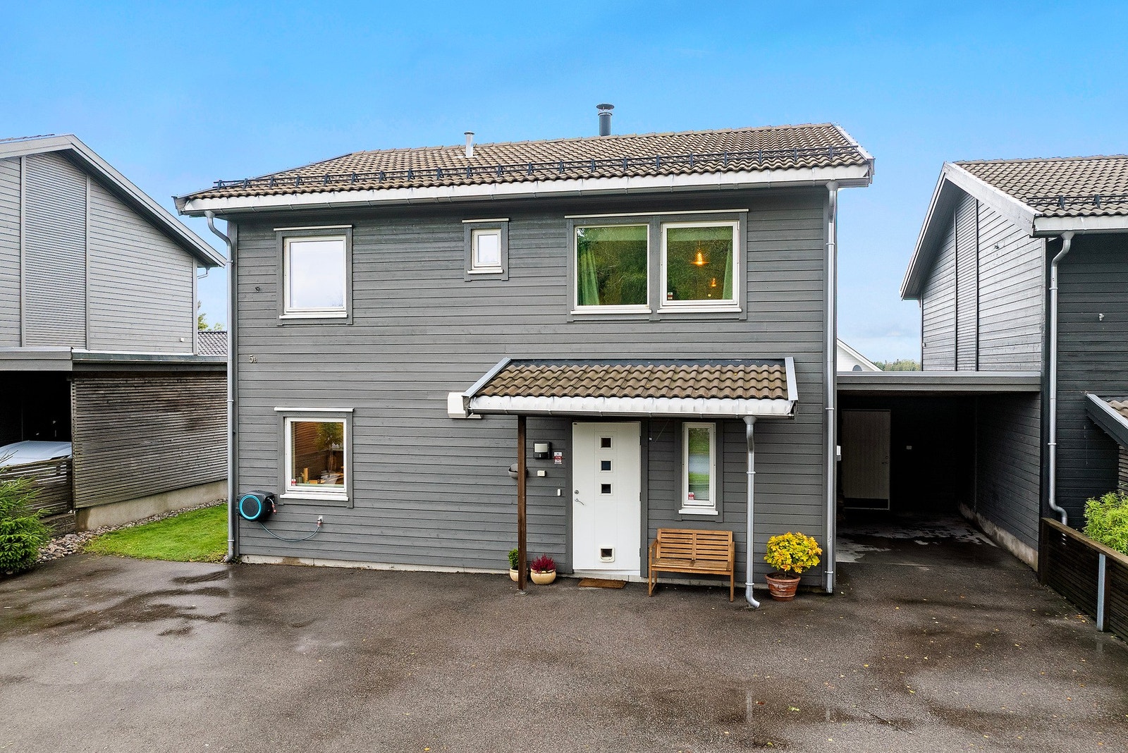 Overbygget inngangsparti og god plass til parkering i asfalter innkjørsel og carport Galleribilde