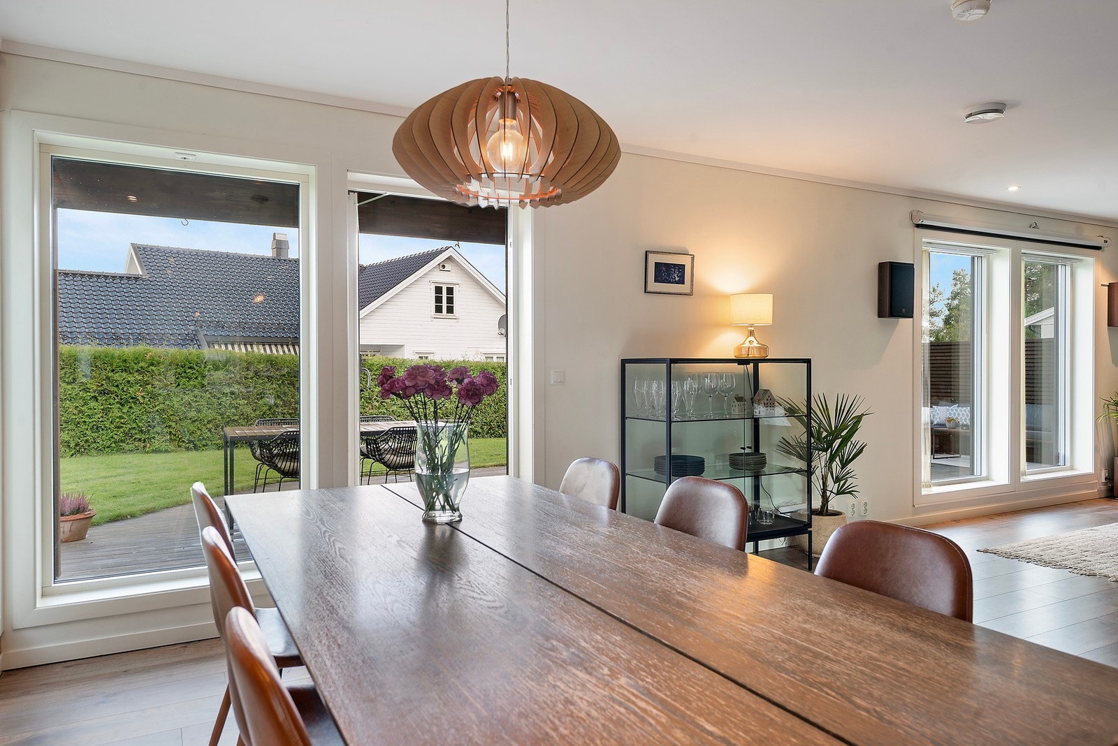 De store vindusflatene åpner opp for et lyst og fredelig utsyn mot hagen, mens hekken sørger for en skjermet og privat atmosfære Galleribilde