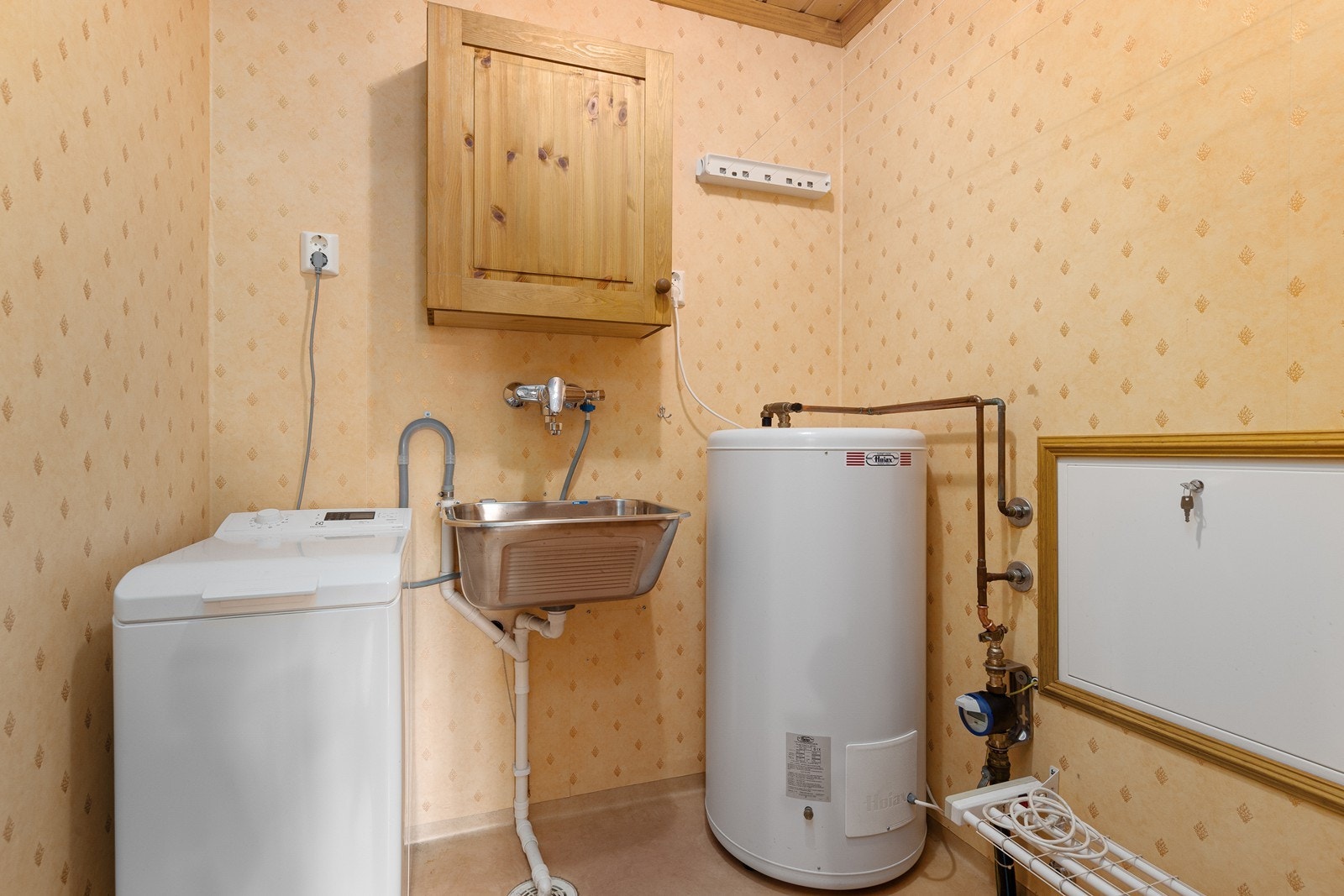 Det praktiske vaskerommet er utstyrt med servant, varmtvannsbereder og opplegg for vaskemaskin. Galleribilde