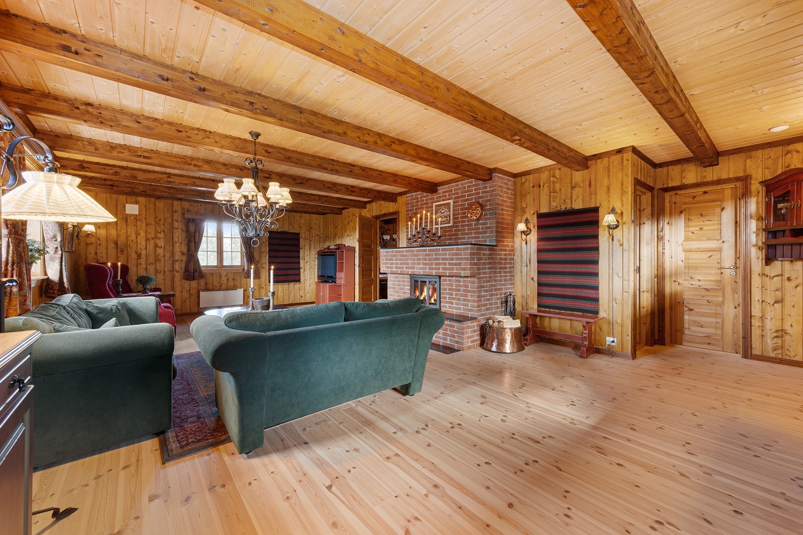 Den innmurte peisinnsatsen fungerer som et naturlig blikkfang og skaper en koselig atmosfære. Galleribilde