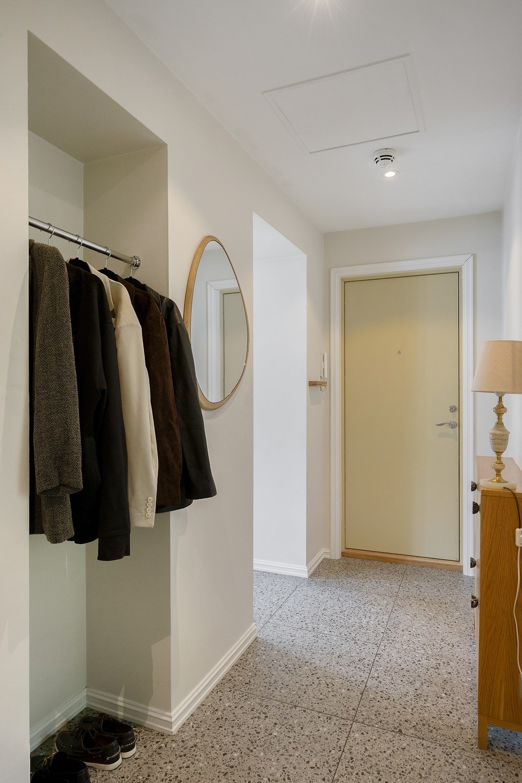 Rommet er pent malt i en lys beige fargetone, og er smart utformet med nisje for oppbevaring av klær og tilbehør. Galleribilde