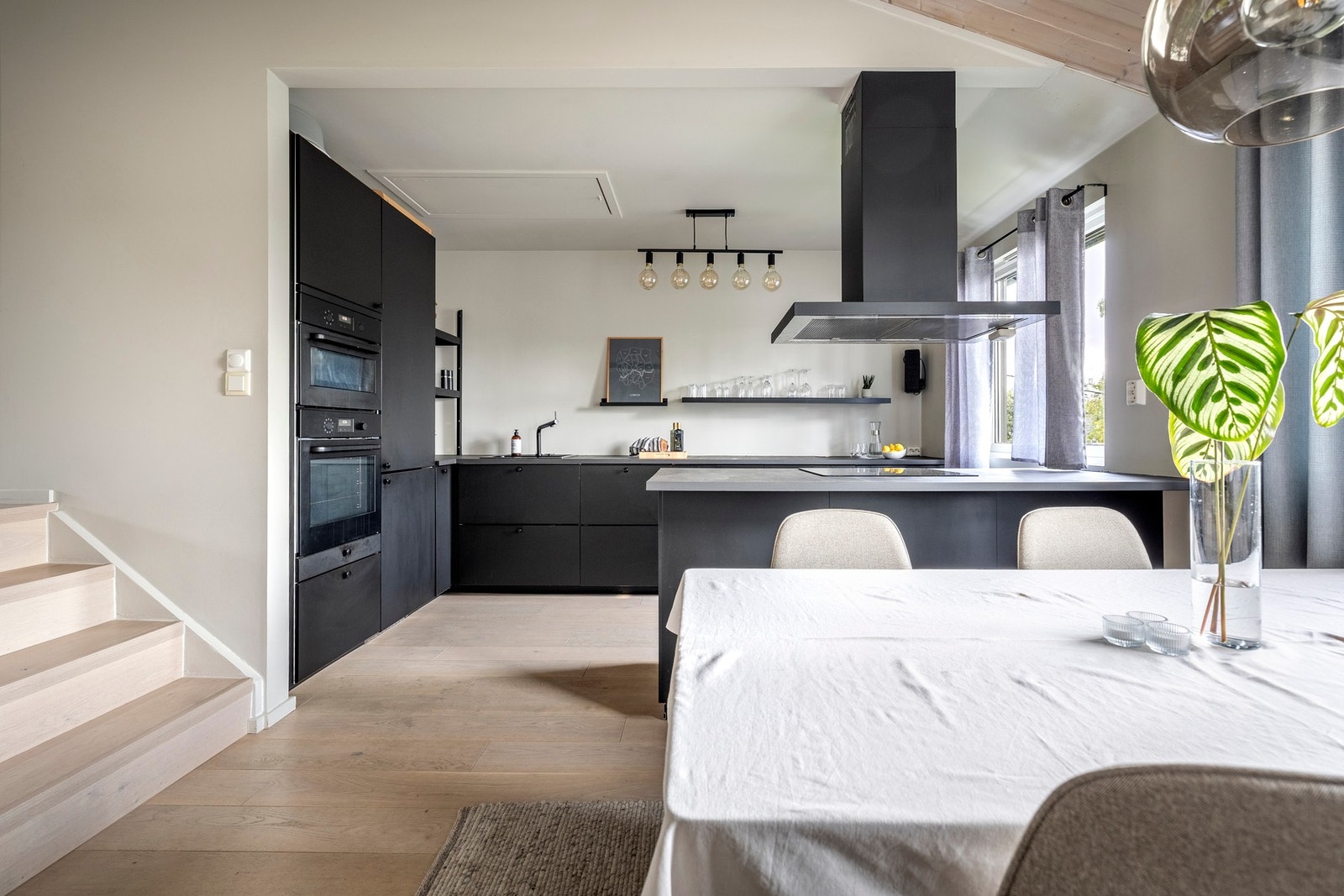 Boligen har en stilren Ikea-kjøkkeninnredning med sorte, slette fronter og malt laminert benkeplate med nedfelt oppvaskkum i kompositt. Galleribilde