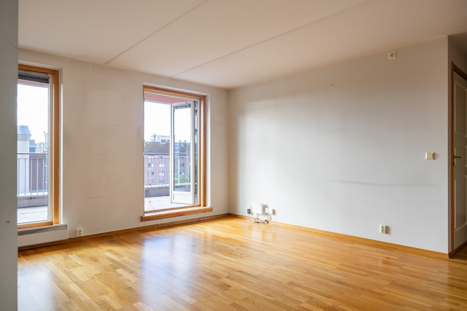 Stuen har store vindusflater og utgang til leilighetens solrike balkong. Galleribilde