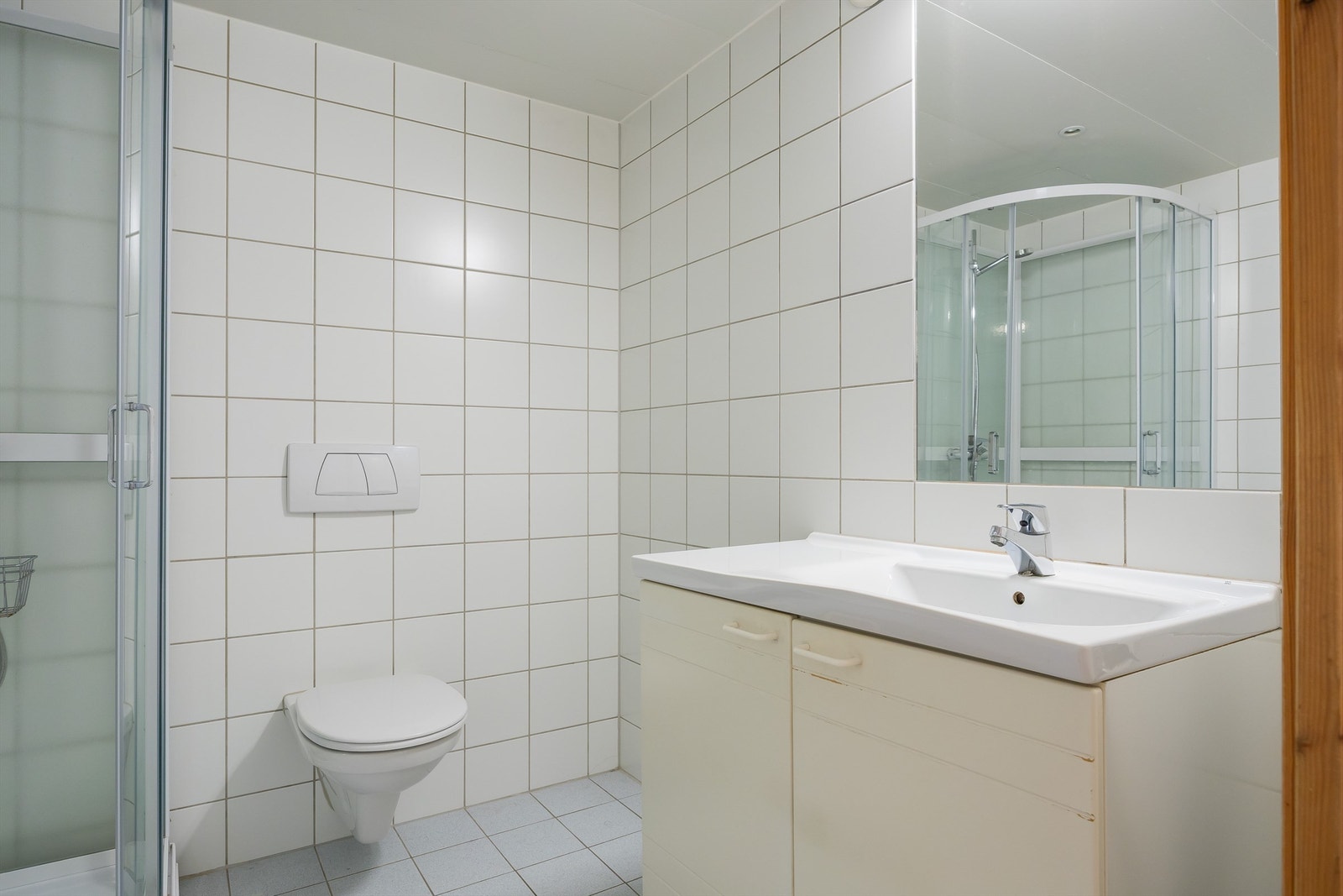 Badet består av flislagte flater, dusjkabinett, servantskap med speil over, samt vegghengt toalett. Galleribilde