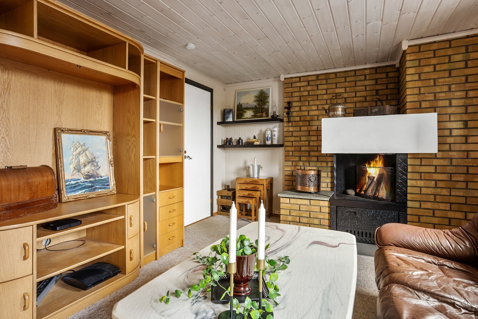 Stuen har godt lysinnslipp og en koselig peis Galleribilde