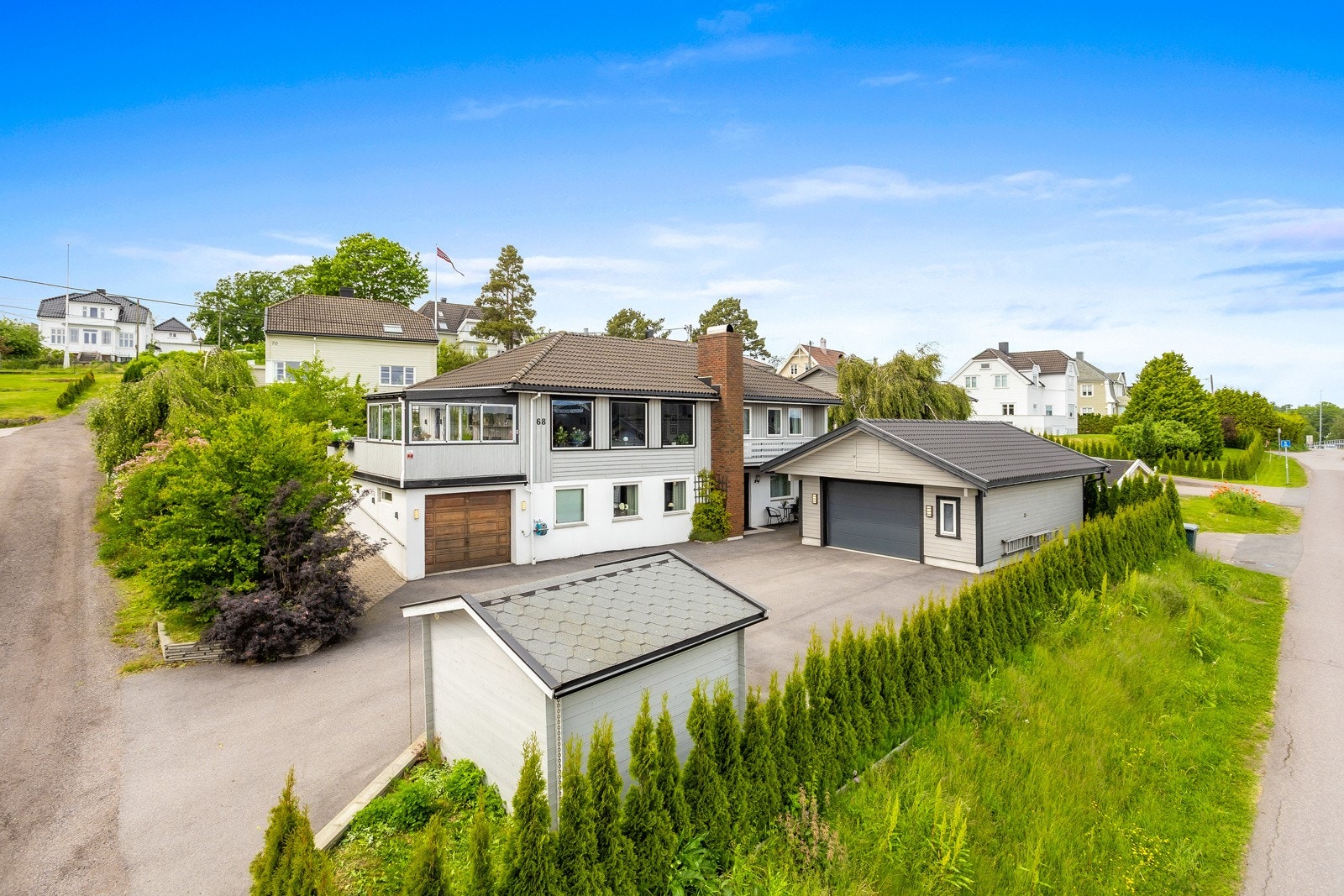 Fasade med gårdsplass og nyere garasje Galleribilde