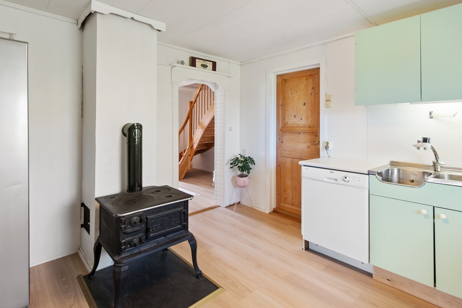 Adkomst til kjøkken fra stue eller innergang. Videre adkomst til en fløy med bad/vaskerom, toalettrom og soverom fra kjøkken. Galleribilde