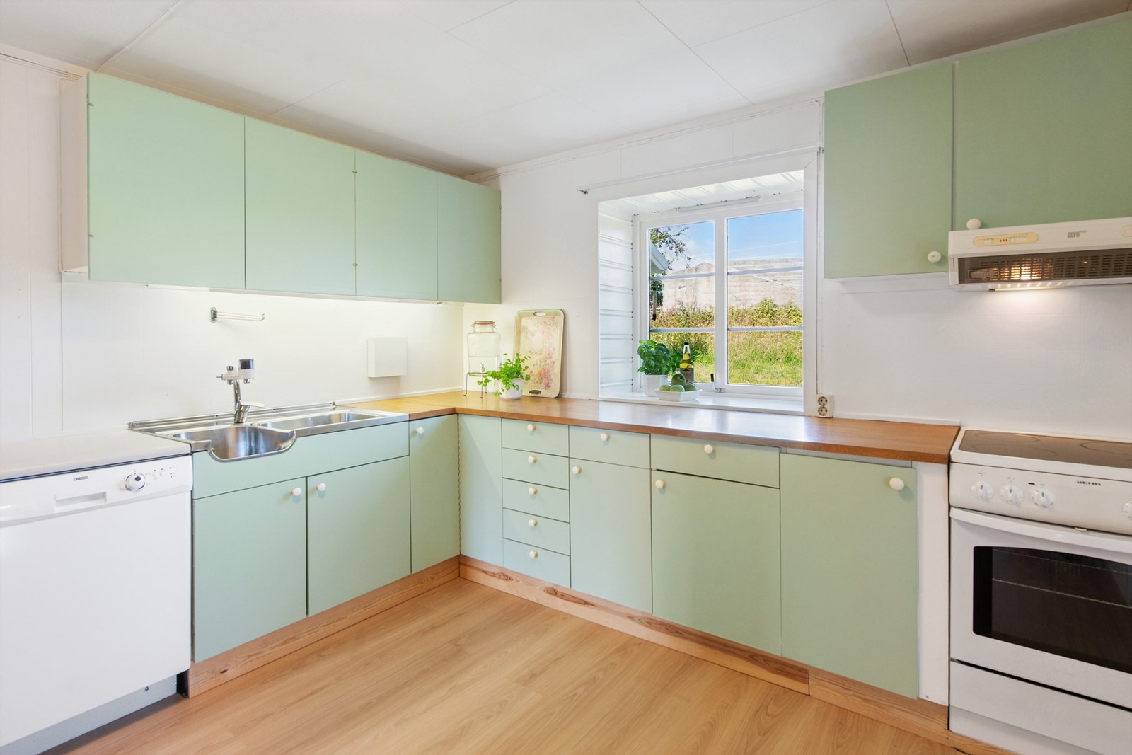 Kjøkkenet har eldre, nymalt kjøkkeninnredning med nye laminatgulv fra 2024. Galleribilde