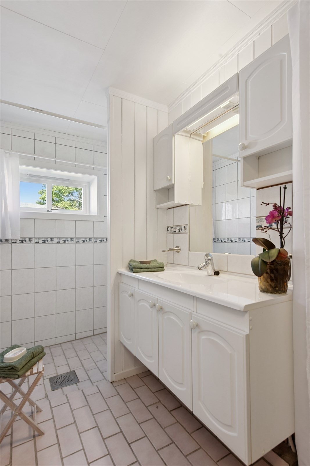 Baderomsinnredning med servant og godt med oppbevaringsplass i over- og underskap. Galleribilde