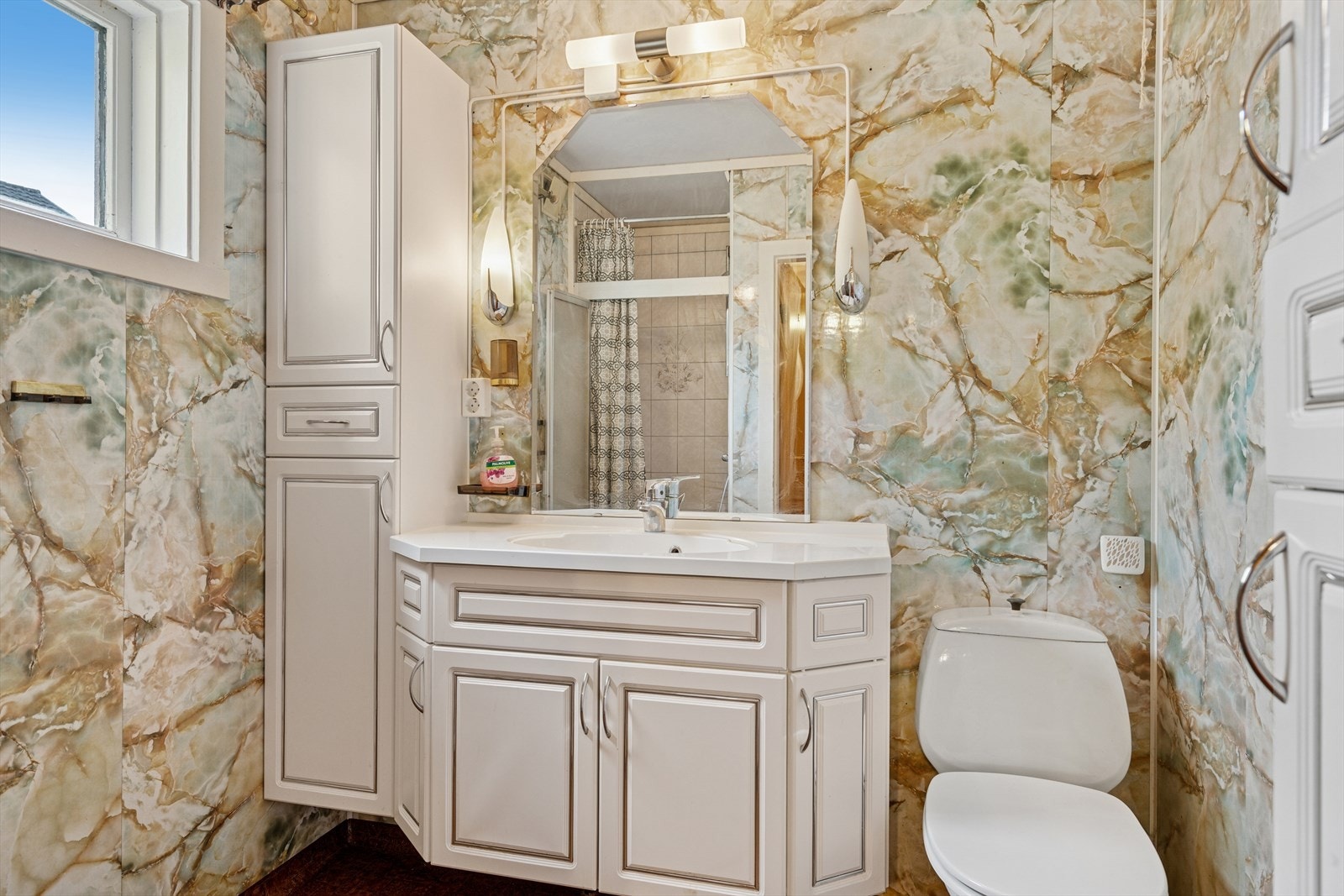 Badet har gulv med vinylbelegg og vegger med fliser/baderomsplater - Her finner du toalett, dusjnisje og baderomsinnredning i lys utførelse Galleribilde