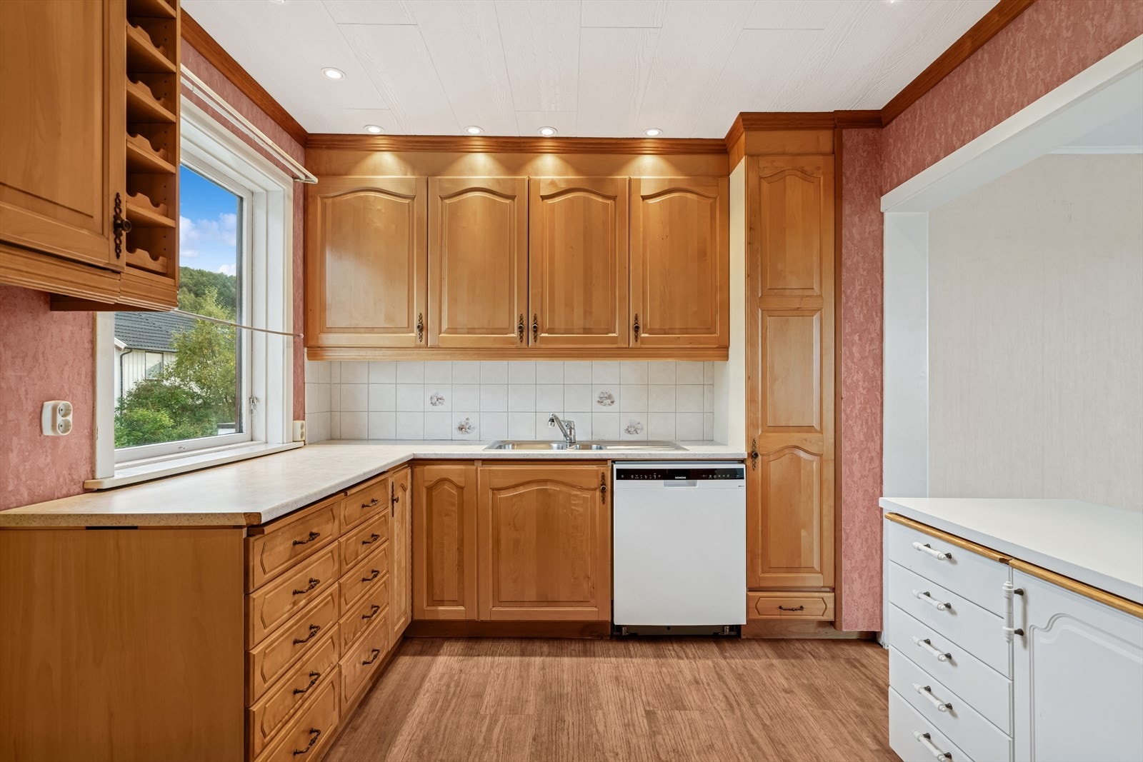 Kjøkkeninnredningen er utført med profilerte fronter og benkeplate i laminat med nedfelt stålvask m/benkebeslag Galleribilde