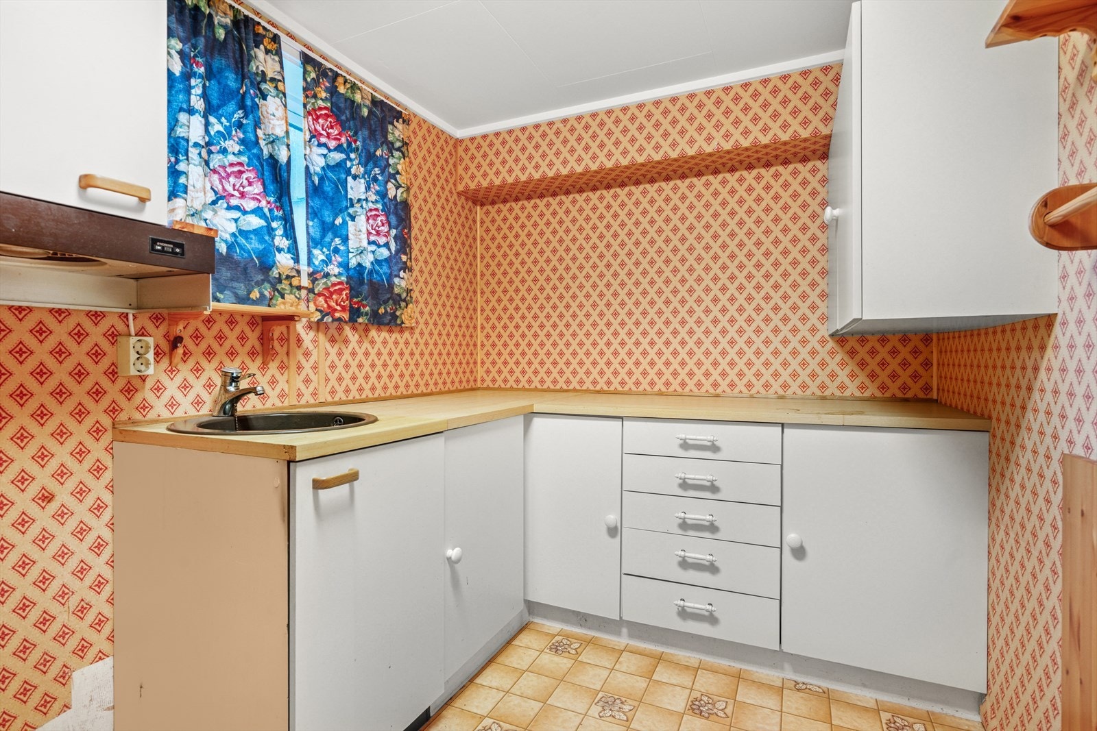 Kjøkkenet har en enkel innredning med slette fronter og benkeplate i laminat - Det er kjøkkenventilator med avtrekk ut Galleribilde