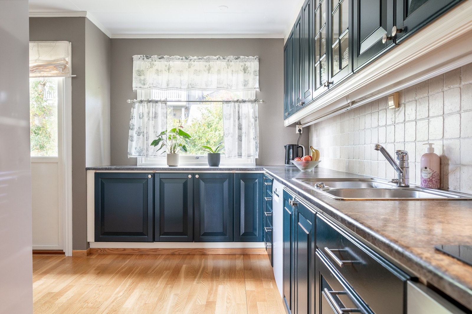 Malt kjøkkeninnredning med profilerte fronter og benkeplater av laminat. Galleribilde