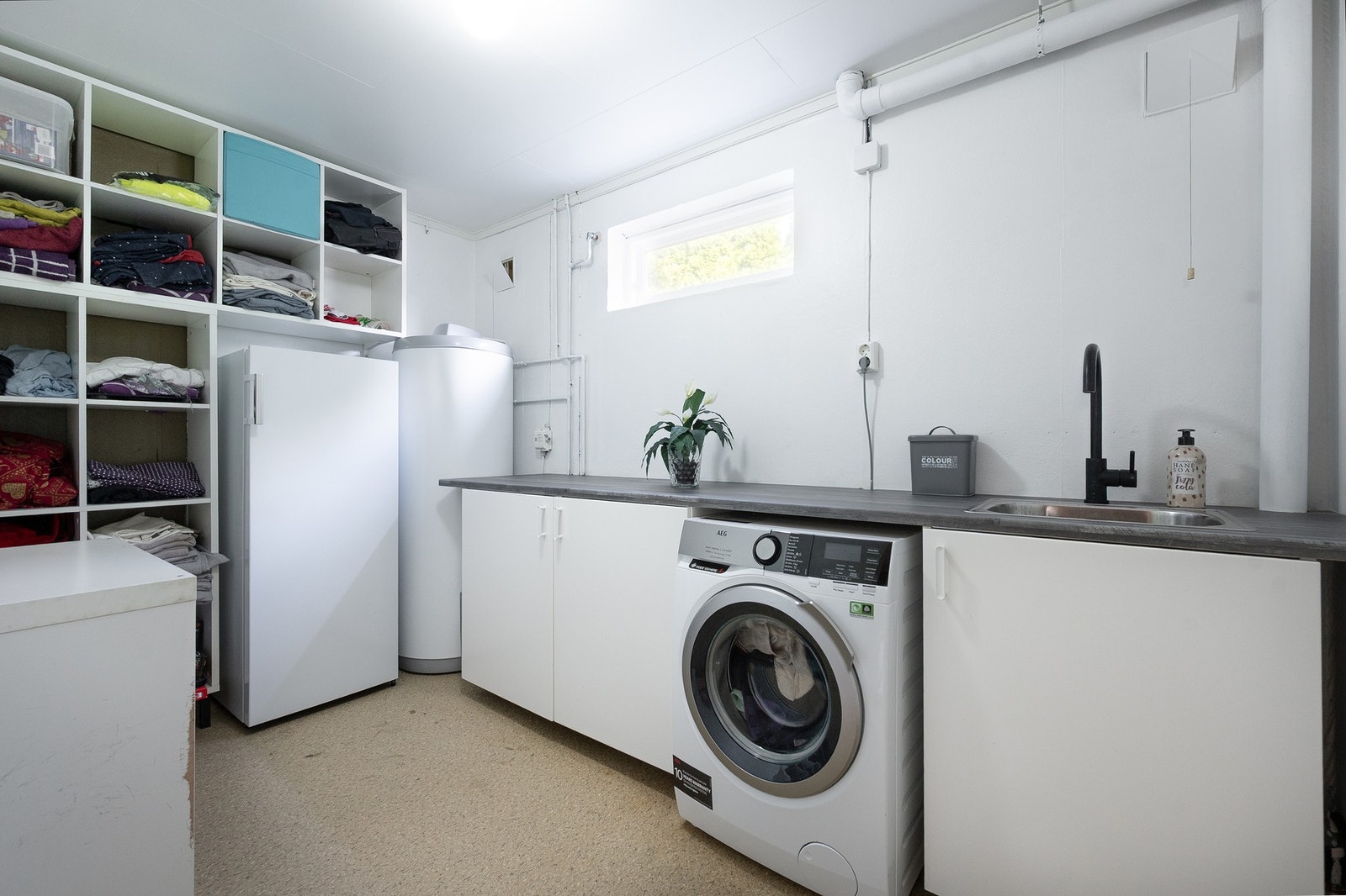 Rommet har skapinnredning, opplegg for vaskemaskin og varmtvannsbereder på ca. 282 liter fra 2019. Galleribilde