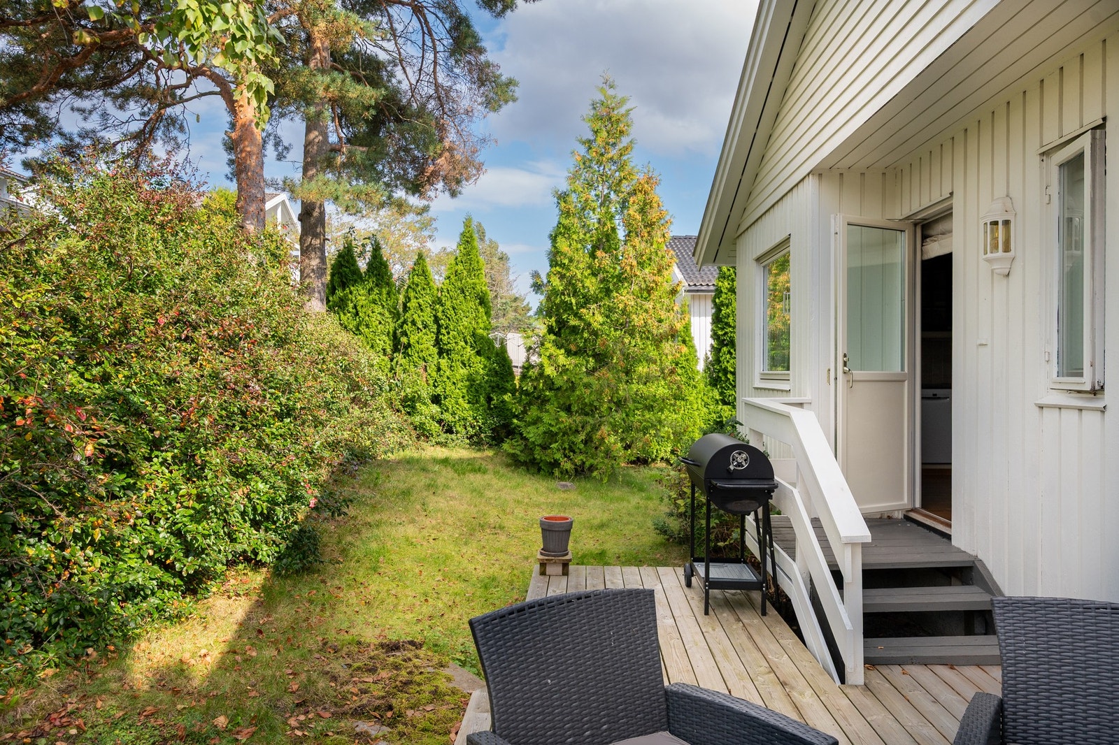 Tomten er opparbeidet med gress, trær, hekk og busker. Galleribilde
