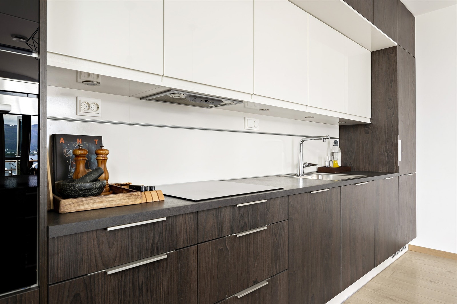 Kjøkkenet har integrerte hvitevarer og spotter under overskap som gir godt med arbeidslys Galleribilde