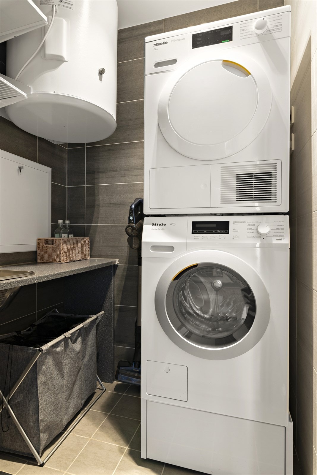 Vaskerom med opplegg for vaskemaskin og tørketrommel, og praktisk benk med vask Galleribilde